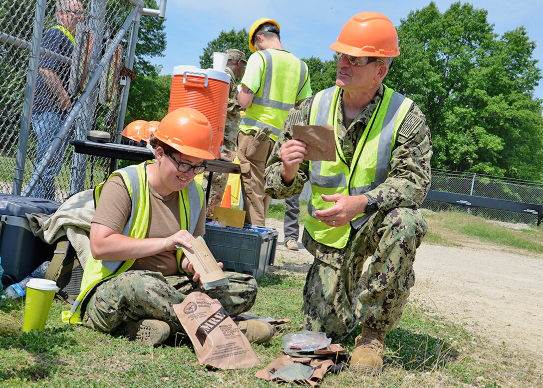 Navy Petty Officer 3rd Class Stephanie Scholz and Chief Petty Officer David Somerville take a break to enjoy their Meal, Ready-to-Eat, commonly referred to as “MREs,” during OCORT in June.