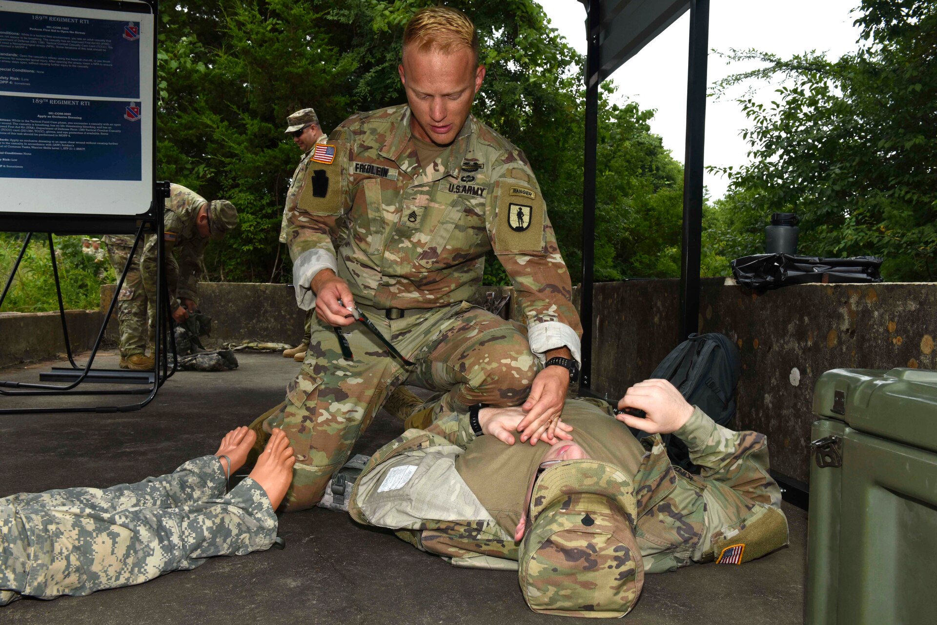 Army Staff Sgt. Erich Friedlein, with the Pennslyvania Army National Guard, prepares to apply an occlusive dressing on a fake casualty during the Army Warrior Tasks portion of the 2019 Army National Guard Best Warrior Competition at Camp Gruber, Oklahoma, July 15, 2019.