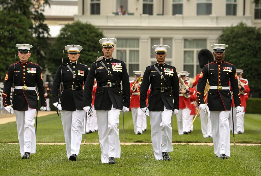 Marines with the Marine Barracks Washington D.C. parade marching staff march across the parade deck for pass in review during a passage of command ceremony at Marine Barracks Washington, D.C., July 11, 2019. General Robert B. Neller relieved his duties as 37th Commandant of the Marine Corps to Gen. David H. Berger, 38th Commandant of the Marine Corps. (U.S. Marine Corps photo by Sgt. Robert Knapp/Released)