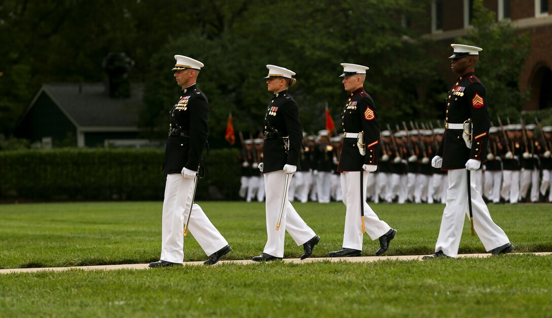 Marines with Marine Barracks Washington parade staff march down Center Walk during a passage of command ceremony at Marine Barracks Washington, D.C., July 11, 2019. General Robert B. Neller relieved his duties as 37th Commandant of the Marine Corps to Gen. David H. Berger, 38th Commandant of the Marine Corps. (U.S. Marine corps photo by Pfc. Allen Sanders)