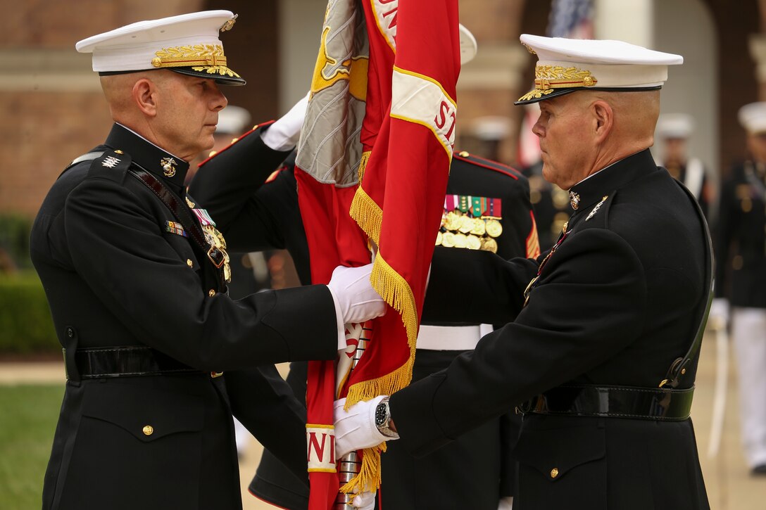 General Robert B. Neller, 37th Commandant of the Marine Corps, passes the Marine Corps Battle Color to Gen. David H. Berger, 38th Commandant of the Marine Corps during a passage of command ceremony at Marine Barracks Washington, D.C., July 11, 2019. General Neller relieved his duties as commandant of the Marine Corps to Gen. Berger. (U.S. Marine Corps photo by Sgt. Robert Knapp/Released)
