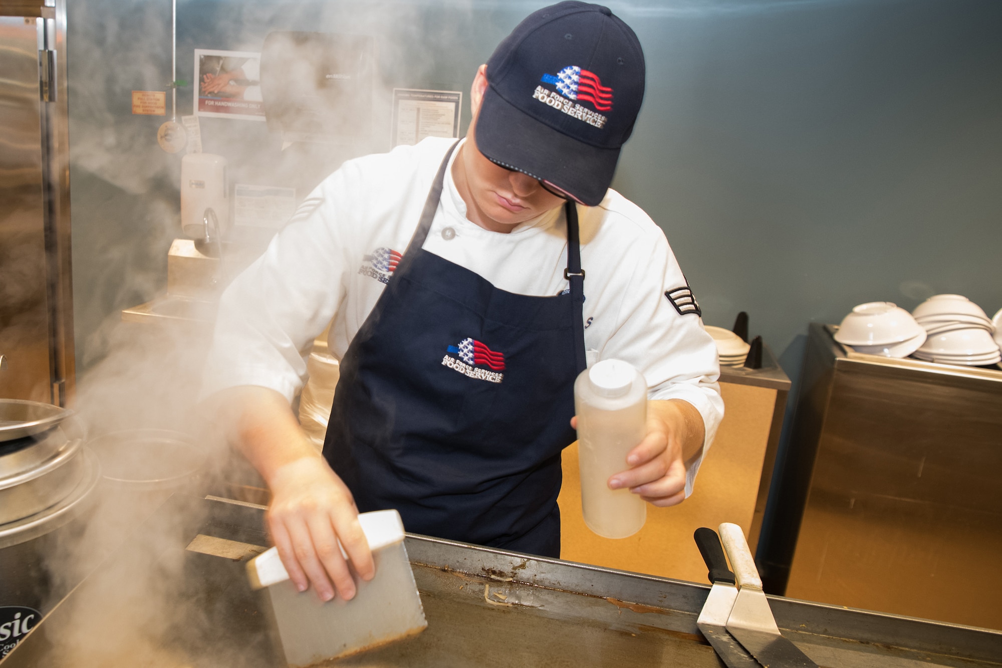 Senior Airman Wesley Samuels, 436th Force Support Squadron services journeyman, cleans the grill after preparing a tofu meal June 11, 2019, at the Patterson Dining Facility Dover Air Force Base, Del. The DFAC offers dozens of menu items daily, including vegan and vegetarian meal options. (U.S. Air Force photo by Mauricio Campino)