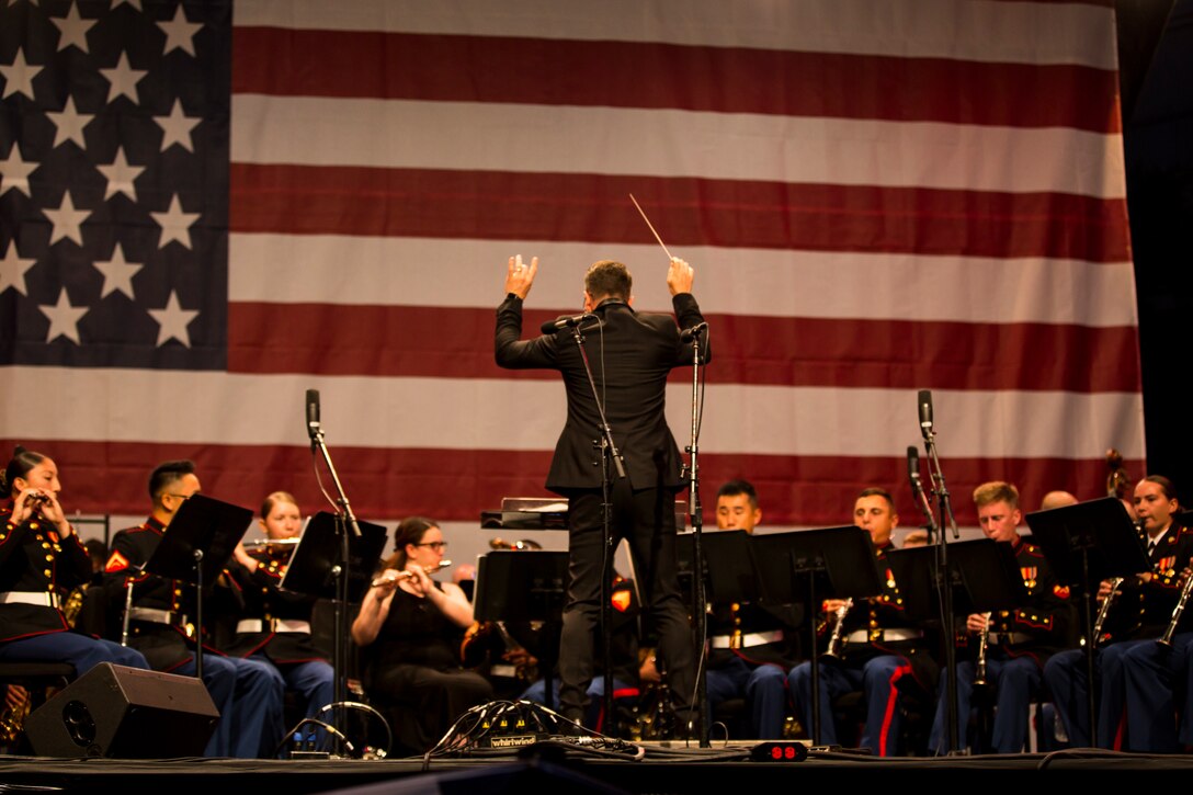 Dr. Ricardo Espinosa, a guest conductor for the 3rd Marine Aircraft Wing (MAW) Band, leads a performance at the California Center for the Arts, Escondido, Calif., July 4, 2019. The 3rd MAW Band spent countless hours of preparation into “An American Celebration” performance, which commemorated Independence Day. (U.S. Marine Corps photo by Lance Cpl. Levi J. Guerra)