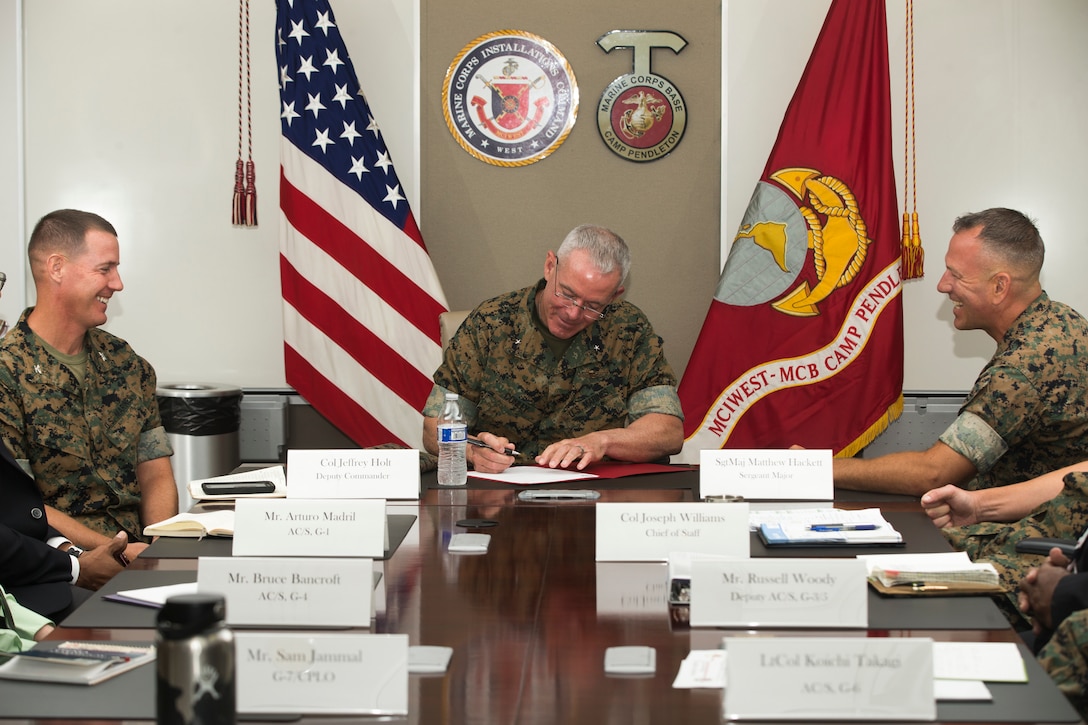 U.S. Marine Brig. Gen. Daniel Conley, center, the new commanding general of Marine Corps Installations West, Marine Corps Base Camp Pendleton, signs a document for his assumption of command at the base headquarters building July 22, 2019. A native of Falmouth, Massachusetts, Conley was commissioned in 1988 as a logistics officer. Conley was previously deployed to Afghanistan as the commander of Bagram Air Field and the deputy commander for U.S. National Support Element – Afghanistan. (U.S. Marine Corps photo by Cpl. Dylan Chagnon)