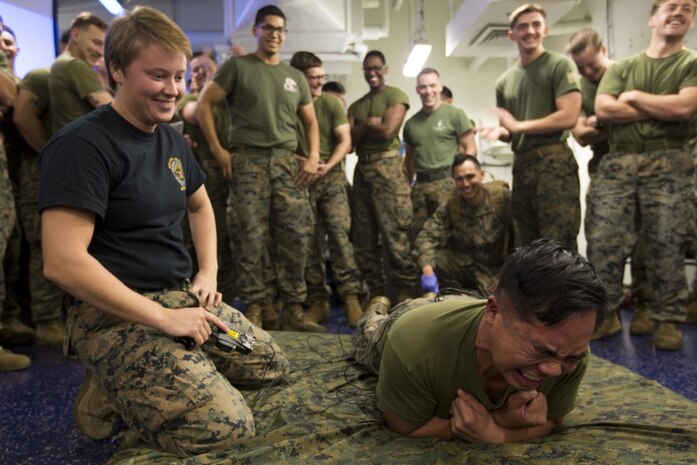 Sgt. Arielle Lahtinen, noncommissioned officer in charge with the 31st MEU's Law Enforcement detachment, tases a Marine with a Conducted Energy Weapon, or TASER, during a non-lethal weapons course aboard the amphibious assault ship USS Wasp (LHD 1), underway in the Coral Sea, June 30, 2019. (Official Marine Corps photo by Lance Cpl. Cameron Parks)