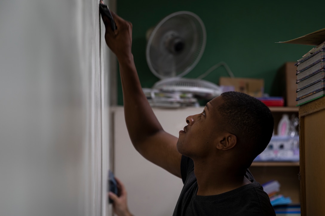 U.S. Marine Corps Cpl. Michael Kearney sands down a wall in preparation for painting at AmerAsian School in Okinawa during a community relations event in Okinawa, Japan, July 15, 2019. Combat Logistics Battalion 4’s chaplain’s office set up this event to help the school with summer cleaning and other various chores. Kearney, a native of Newark, New Jersey, is a motor vehicle operator with 3rd Platoon, Transportation Services Company, CLB-4, Combat Logistics Regiment 3. (U.S. Marine Corps photo by Cpl. Jamin M. Powell)