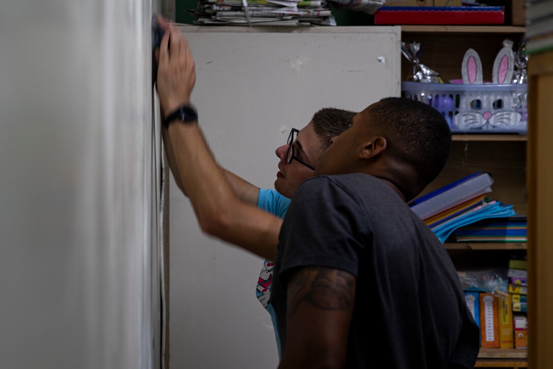 U.S. Marine Corps Pfc. Nicolas Palumbo, left, and Cpl. Michael Kearney, sand down a wall in preparation for painting at AmerAsian School in Okinawa during a community relations event in Okinawa, Japan, July 15, 2019. Combat Logistics Battalion 4’s chaplain’s office set up this event to help the school with summer cleaning and other various chores. Palumbo, a native of Newburgh, New York, is a landing support specialist with Landing Support Platoon, Transportation Services Company, CLB-4, Combat Logistics Regiment 3. Kearney, a native of Newark, New Jersey, is a motor vehicle operator with 3rd Platoon, Transportation Services Company, CLB-4, CLR-3. (U.S. Marine Corps photo by Cpl. Jamin M. Powell)