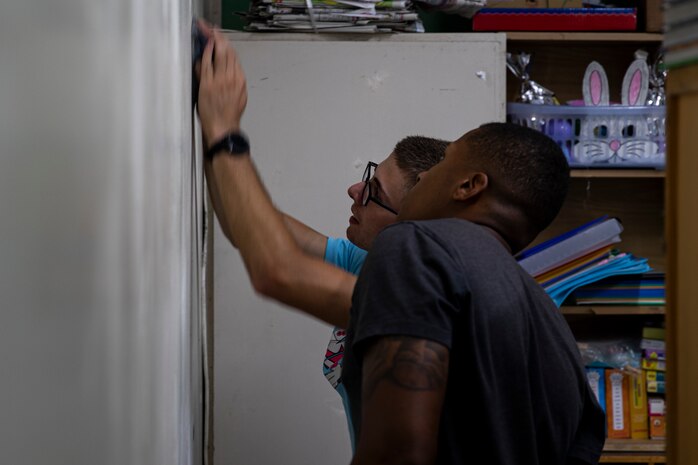 U.S. Marine Corps Pfc. Nicolas Palumbo, left, and Cpl. Michael Kearney, sand down a wall in preparation for painting at AmerAsian School in Okinawa during a community relations event in Okinawa, Japan, July 15, 2019. Combat Logistics Battalion 4’s chaplain’s office set up this event to help the school with summer cleaning and other various chores. Palumbo, a native of Newburgh, New York, is a landing support specialist with Landing Support Platoon, Transportation Services Company, CLB-4, Combat Logistics Regiment 3. Kearney, a native of Newark, New Jersey, is a motor vehicle operator with 3rd Platoon, Transportation Services Company, CLB-4, CLR-3. (U.S. Marine Corps photo by Cpl. Jamin M. Powell)