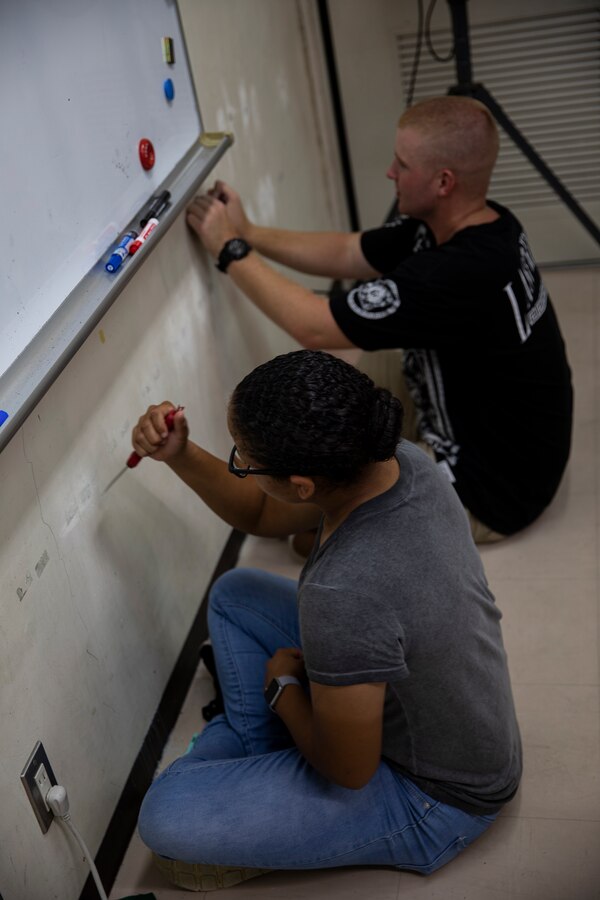 U.S. Marine Corps Pfc. Aliyah Nolan, left, and Pfc. Tyler Roberts, right, sand down a wall in preparation for painting at AmerAsian School in Okinawa during a community relations event in Okinawa, Japan, July 15, 2019. Combat Logistics Battalion 4’s chaplain’s office set up this event to help the school with summer cleaning and other various chores. Nolan, a native of Marino Valley, California, is a motor vehicle operator with 3rd Platoon, Transportation Services Company, CLB-4, Combat Logistics Regiment 3. Roberts, a native of Sacramento, California, is a motor vehicle operator with 3rd Plt., TS Co., CLB-4, CLR-3. (U.S. Marine Corps photo by Cpl. Jamin M. Powell)