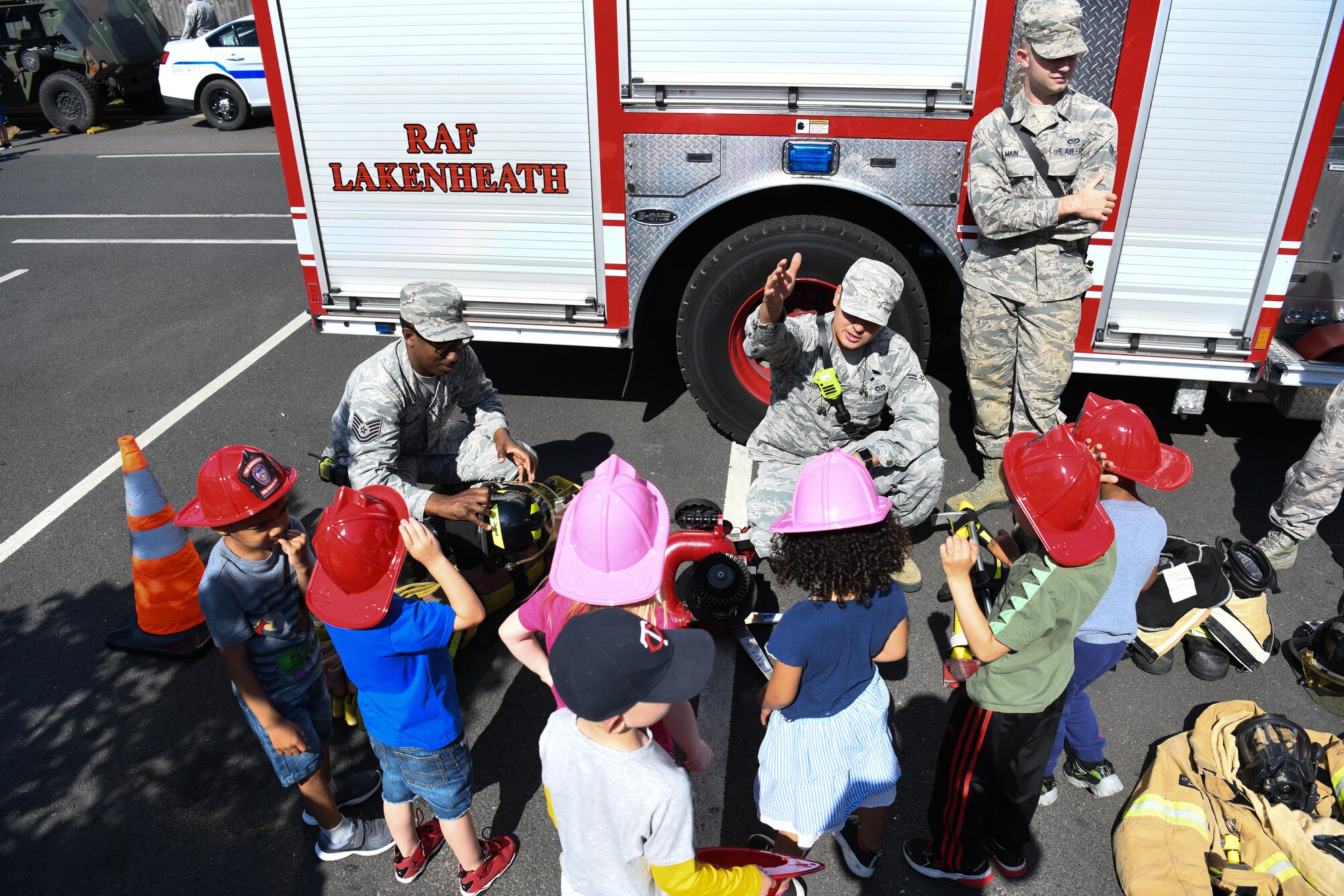A 48th Civil Engineer Squadron firefighter gives a fire safety brief to children during an interactive vehicle display at Royal Air Force Lakenheath, England, July 3, 2019. The event was hosted by the 48th Logistics Readiness squadron, allowing the children to interact with the Airmen who work in transportation and contribute to the nation’s safety and defense. (U.S. Air Force photo by Airman 1st Class Shanice Williams-Jones)
