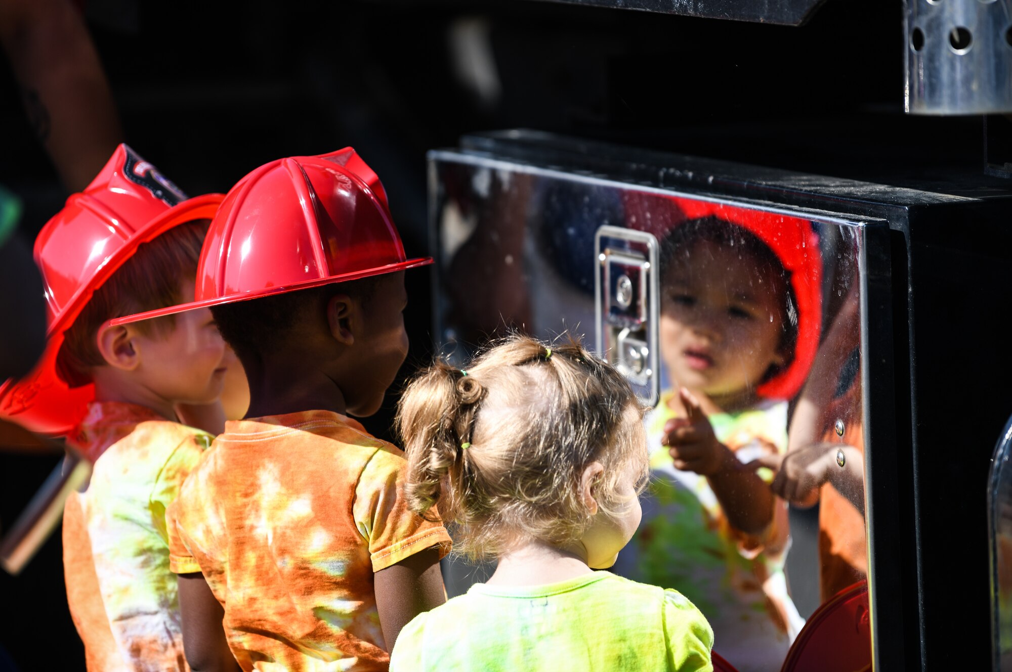 Children press a button on a wrecker tool box during an interactive vehicle display hosted by the 48th Logistic Readiness Squadron at Royal Air Force Lakenheath, England, July 3, 2019. 48th LRS displayed transportation and support vehicles, allowing the children to interact with the Airmen who work in transportation and contribute to the nation’s safety and defense.