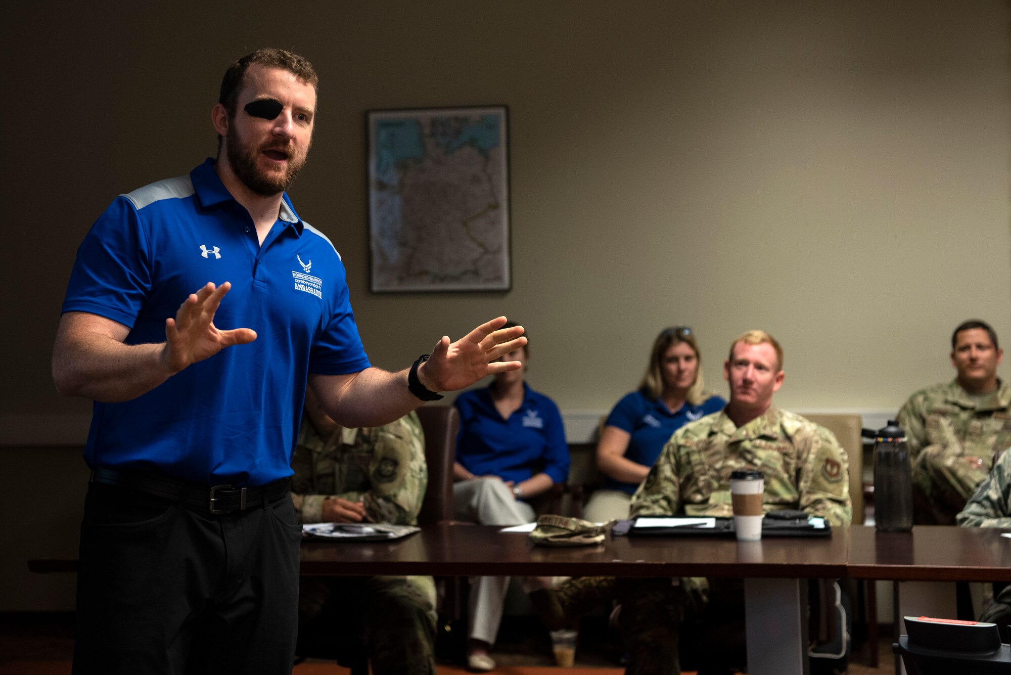 Brett Campfield, U.S. Air Force Wounded Warrior Program ambassador, left, speaks at a first sergeant council meeting at Spangdahlem Air Base, Germany, July 23, 2019. Campfield was a senior Airman when he lost an eye in an explosive ordnance disposal accident. The Wounded Warrior Program gave him personalized service and support during his recovery. The program takes care of members as they either return back to duty, separate, or retire from the military. (U.S. Air Force photo by Airman 1st Class Valerie Seelye)