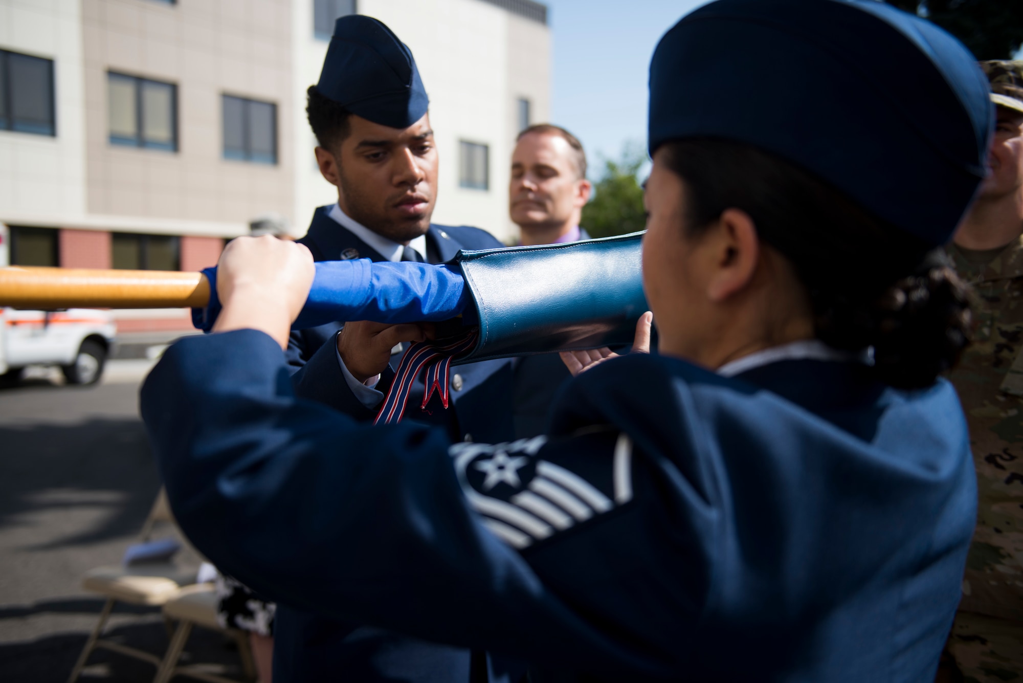 U.S. Air Force Master Sgt. Brittany Zavala, 92nd Health Care Operations Squadron superintendent, covers the 92nd Medical Operations Squadron?? guidon as part of the 92nd Medical Group re-designation ceremony at Fairchild Air Force Base, Washington, July 19, 2019. The 92nd MDG initiated the first phase of its re-designation program by hosting a ceremony renaming the 92nd AMDS  to the 92nd Operational Medical Readiness Squadron and the 92nd Medical Operations Squadron to the 92nd Health Care Operations Squadron. (U.S. Air Force photo by Airman 1st Class Lawrence Sena)