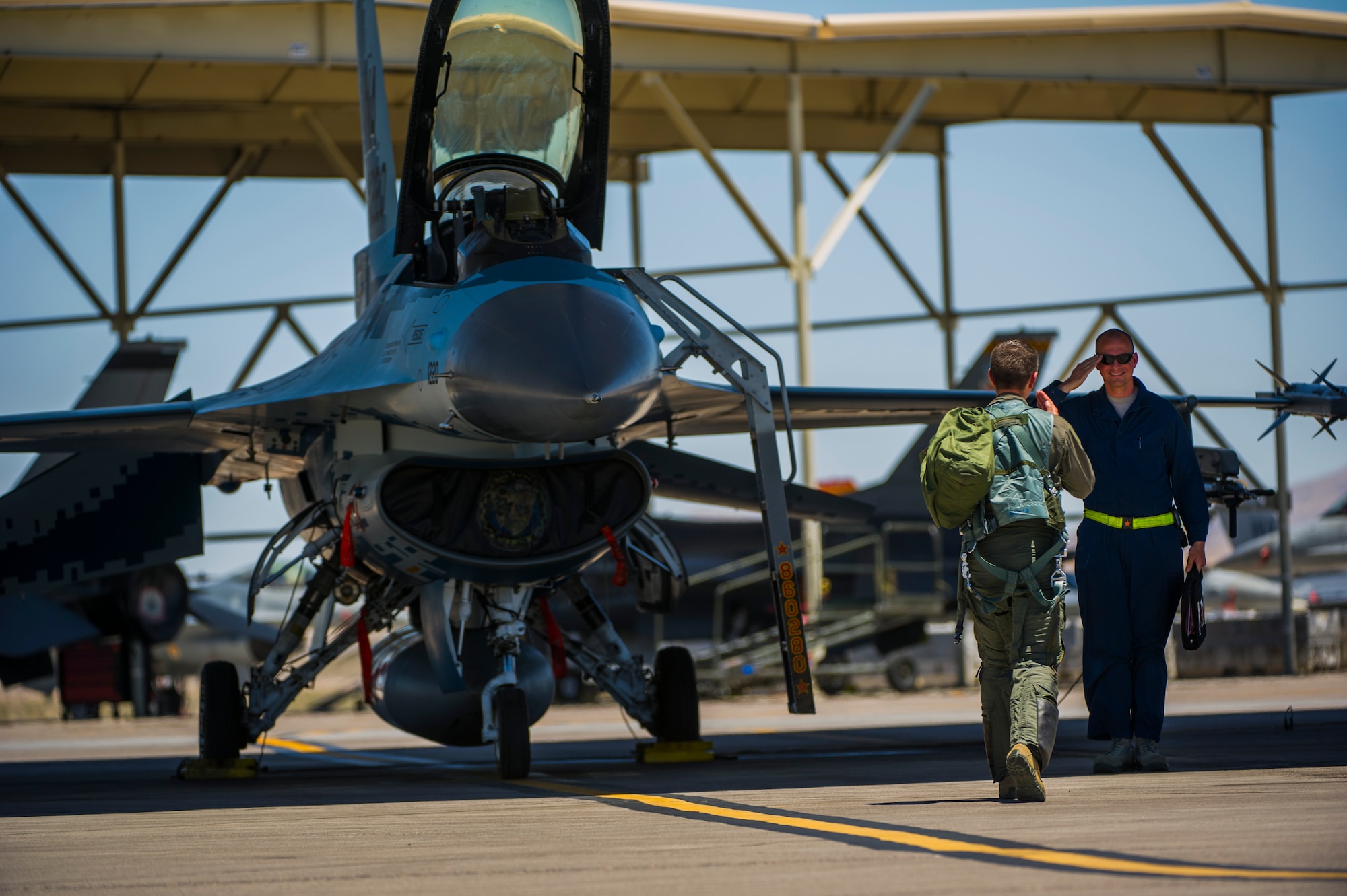 Lt. Col. Jan Stahl, 706th Fighter Squadron commander, renders a salute to Airman 1st Class Russell Lee, 57th Aircraft Maintenance Squadron crew chief July 16, 2019, at Nellis Air Force Base, Nev. Red Flag focuses on the application of core missions to include Command and Control, Intelligence Surveillance, Strike and Personnel Recovery and how to work with Coalition counterparts to ensure success. The 706th Fighter Squadron oversees Air Force Reserve Command members assigned to the U.S. Air Force Warfare Center, supporting missions in its 57th Wing, 53rd Wing and 505th Command and Control Wing. Pilots assigned to the 706 FS fly an array of aircraft to include the F-15C, F-15E, F-16, F-22 and F-35 aircraft. To prepare combat air forces, joint and allied crews with realistic training, pilots in the 706 FS operate with the 64th Aggressor Squadron to facilitate operational threat replication, training, and feedback. The Red Flag exercise will continue through July 26, 2019.