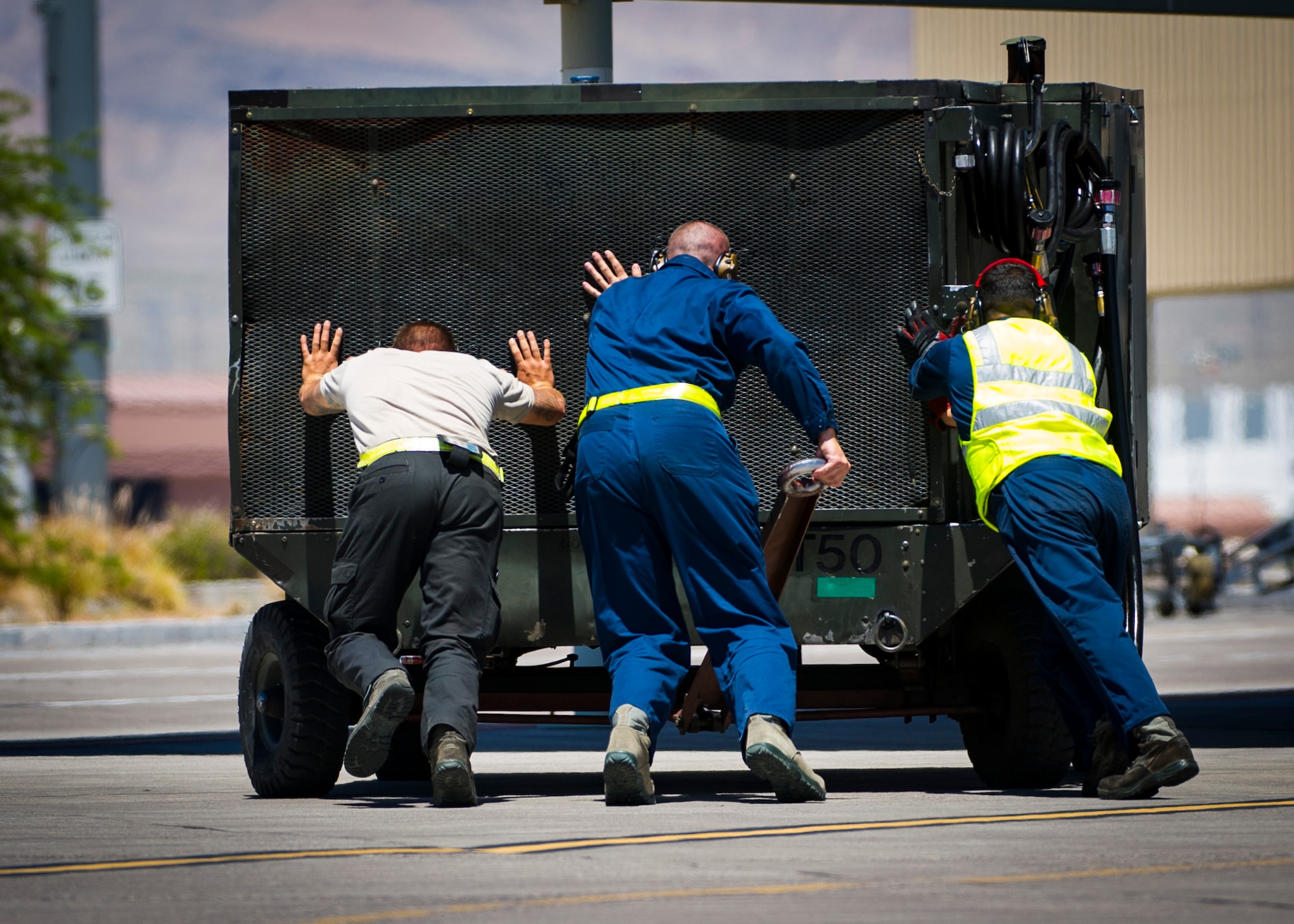 Crew chiefs assigned to the 57th Aircraft Maintenance Squadron push a aircraft hydraulic power supply July 13, 2019, at Nellis Air Force Base, Nev. Red Flag focuses on the application of core missions to include Command and Control, Intelligence Surveillance, Strike and Personnel Recovery and how to work with Coalition counterparts to ensure success. The 706th Fighter Squadron oversees Air Force Reserve Command members assigned to the U.S. Air Force Warfare Center, supporting missions in its 57th Wing, 53rd Wing and 505th Command and Control Wing. Pilots assigned to the 706 FS fly an array of aircraft to include the F-15C, F-15E, F-16, F-22 and F-35 aircraft. To prepare combat air forces, joint and allied crews with realistic training, pilots in the 706 FS operate with the 64th Aggressor Squadron to facilitate operational threat replication, training, and feedback. The Red Flag exercise will continue through July 26, 2019.