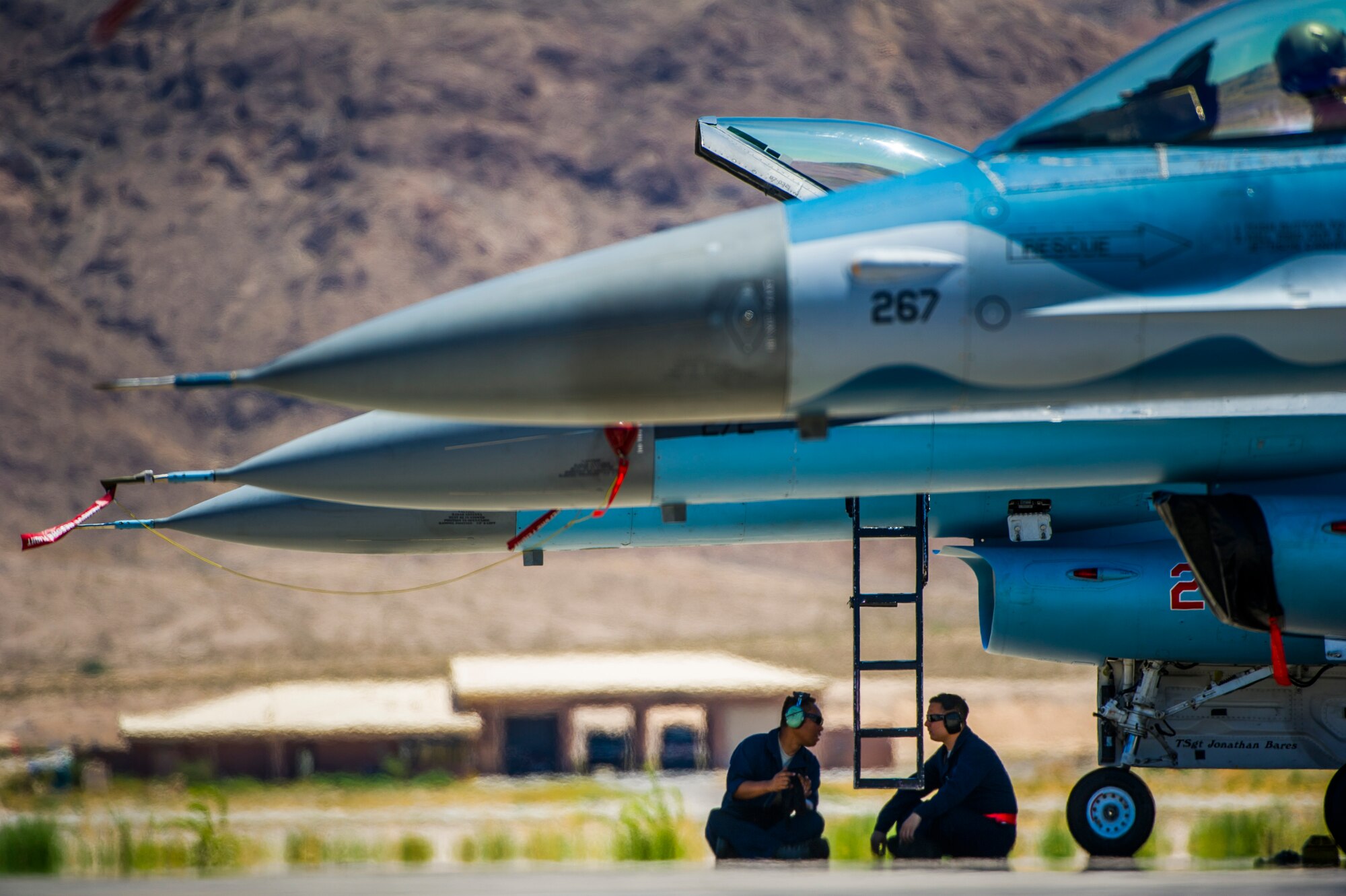 Crew chiefs assigned to the 57th Aircraft Maintenance Squadron rest underneath an F-16 fighting falcon July 13, 2019, at Nellis Air Force Base, Nev. Historically, temperatures at Nellis have reached over 118 degrees Fahrenheit. Red Flag focuses on the application of core missions to include Command and Control, Intelligence Surveillance, Strike and Personnel Recovery and how to work with Coalition counterparts to ensure success. The 706th Fighter Squadron oversees Air Force Reserve Command members assigned to the U.S. Air Force Warfare Center, supporting missions in its 57th Wing, 53rd Wing and 505th Command and Control Wing. Pilots assigned to the 706 FS fly an array of aircraft to include the F-15C, F-15E, F-16, F-22 and F-35 aircraft. To prepare combat air forces, joint and allied crews with realistic training, pilots in the 706 FS operate with the 64th Aggressor Squadron to facilitate operational threat replication, training, and feedback. The Red Flag exercise will continue through July 26, 2019.