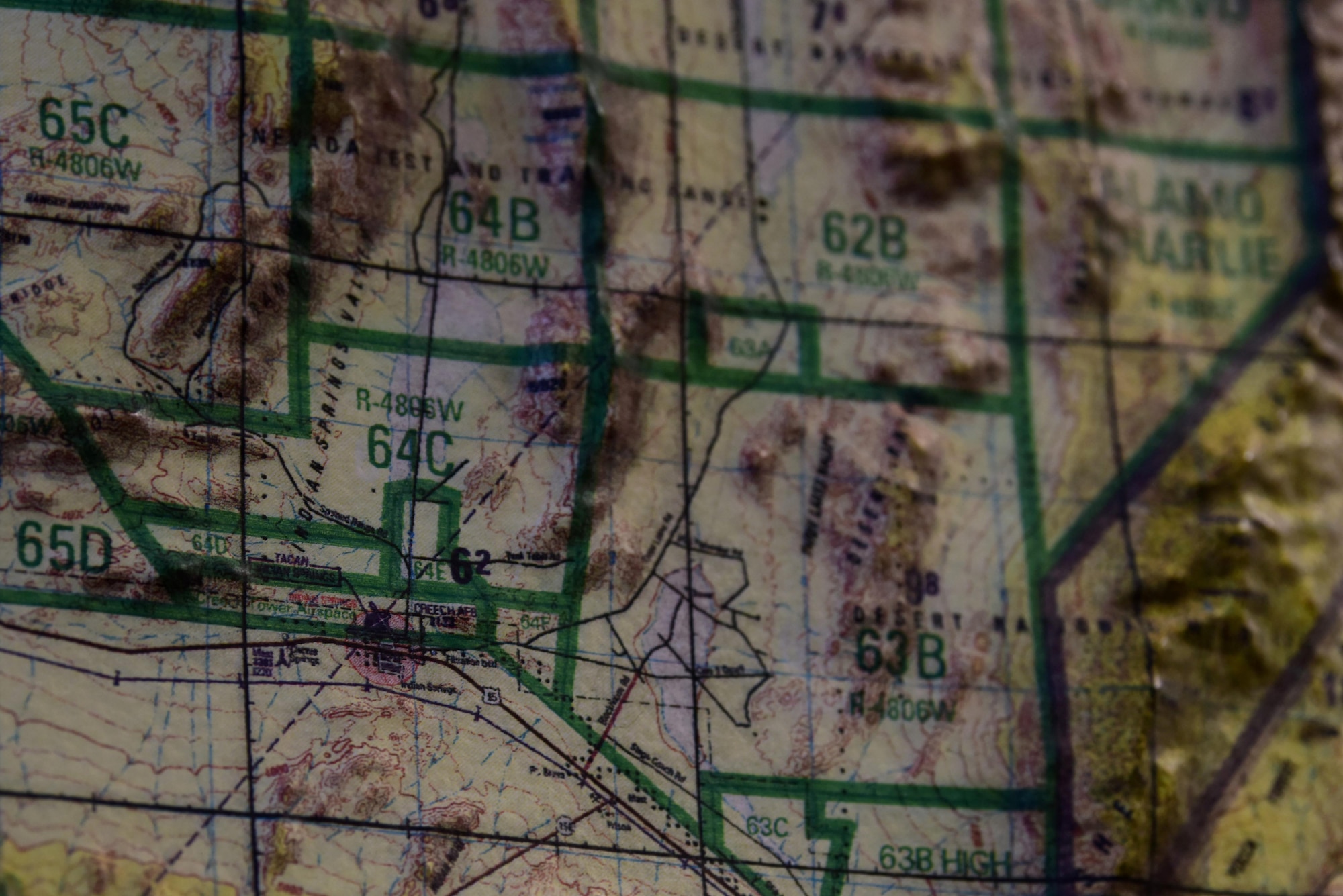 Creech Air Force Base, the home of the Hunters and the MQ-9 Reaper, is displayed on maps in the 66th Rescue Squadron at Nellis Air Force Base, Nevada, July 15, 2019. Before taking to the skies, aircrew will review a map and demonstrate flight paths to identify any areas that need special attention during flight. (U.S. Air Force photo by Senior Airman Haley Stevens)