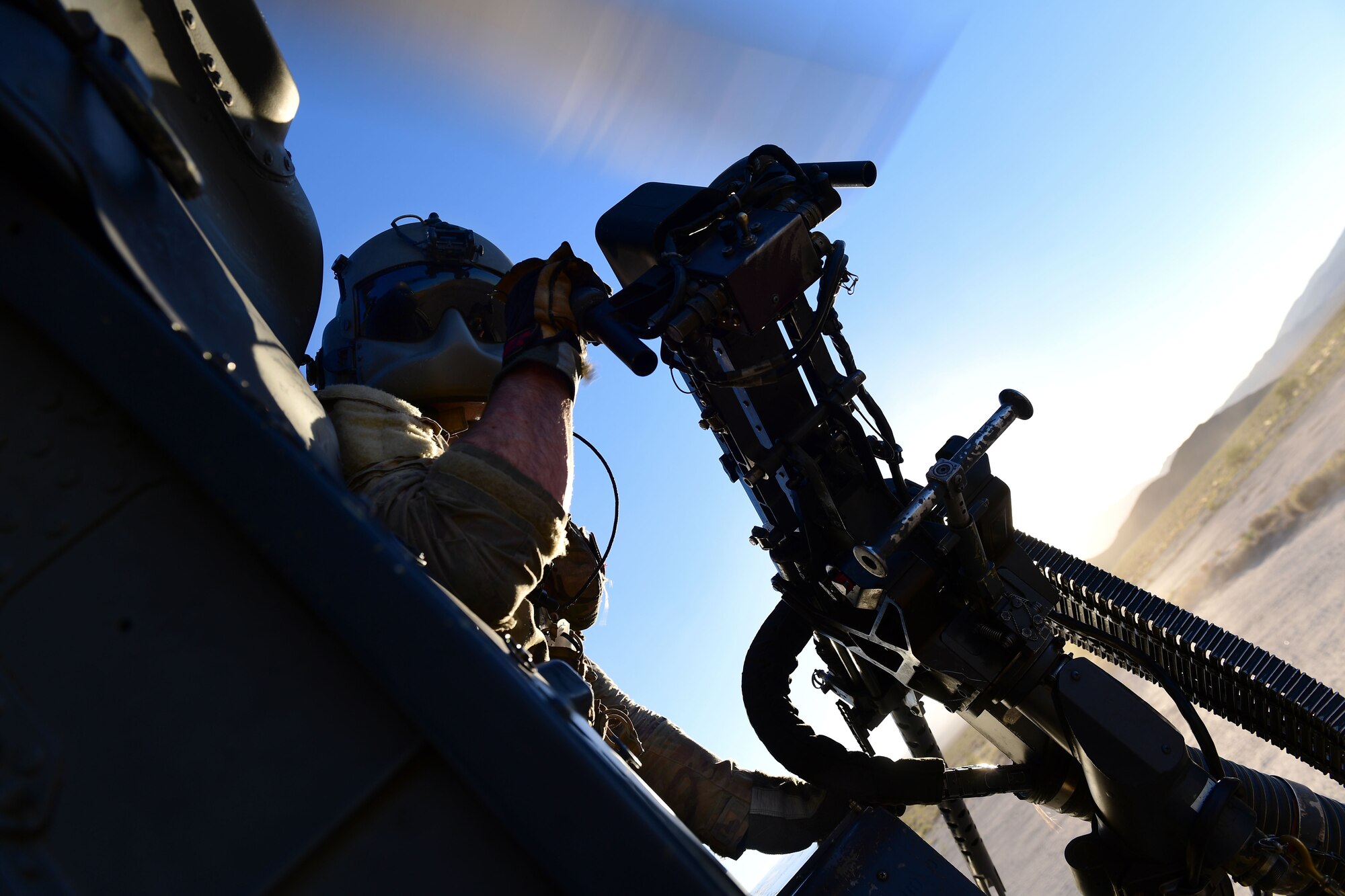 Senior Airman Kevin Belgrade, 66th Rescue Squadron special missions aviator, checks outside of the helicopter as it lands in the Nevada Test and Training Range, July 15, 2019. Special missions aviators are responsible for pre-flight inspections of aircraft systems, cargo delivery, monitoring all aircraft functions, and even providing weapon defense when necessary. (U.S. Air Force photo by Senior Airman Haley Stevens)