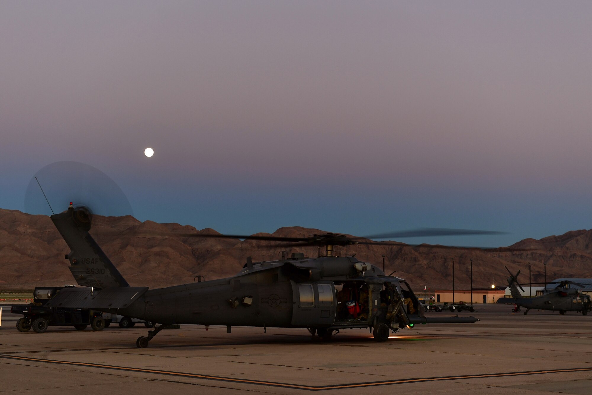 Airmen perform post-flight checks on an HH-60G Pave Hawk at Nellis Air Force Base, Nevada, July 15, 2019. The Pave Hawk is a highly modified version of the Army Black Hawk helicopter and its aircrews support day or night recovery operations in hostile environments. (U.S. Air Force photo by Senior Airman Haley Stevens)