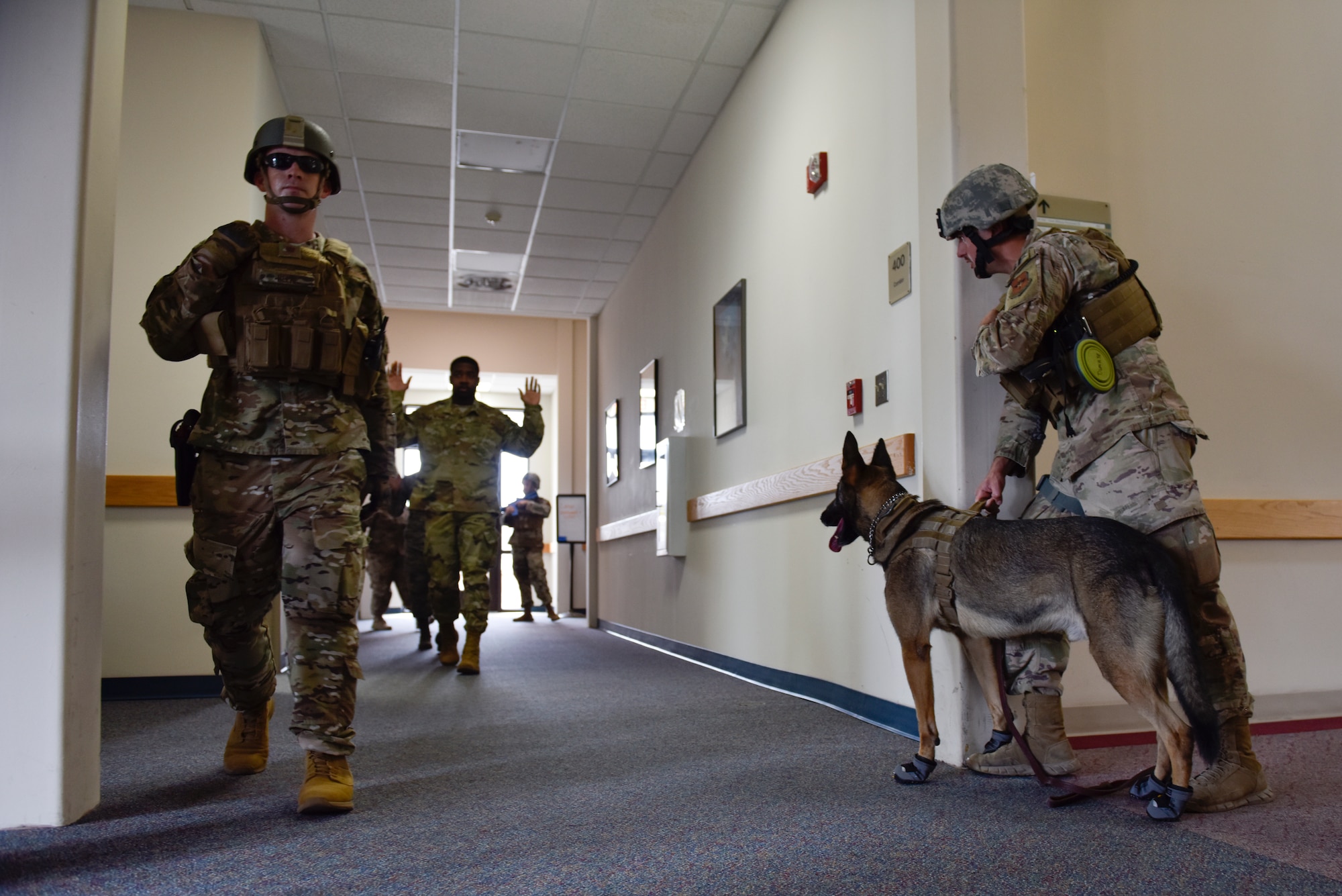 Members of the 47th Security Forces Squadron clear the area during a training exercise at Laughlin Air Force Base, Texas, July 22, 2019. Shortly after apprehending the simulated suspect, the defenders carried on to clear the rest of the building to ensure there was no longer a threat. Exercises like this one are aimed at bolstering crisis readiness and response capabilities. (U.S. Air Force photo by Staff Sgt. Benjamin N. Valmoja)