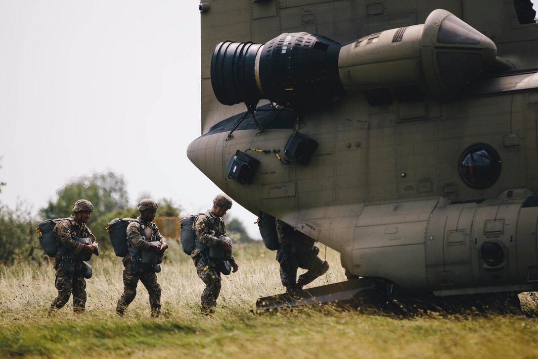 Four soldiers walk into an aircraft.