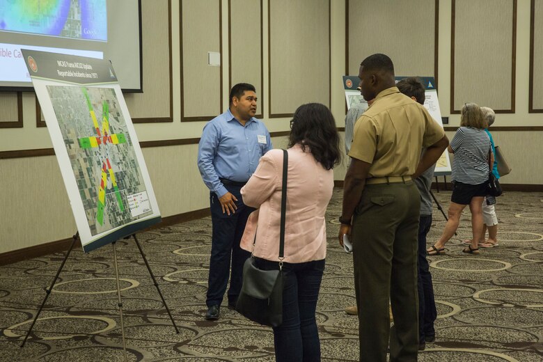 Col. David A. Suggs, the commanding officer of Marine Corps Air Station (MCAS) Yuma, and several base personnel interact with members of the local Yuma community during the Air Installations Compatible Use Zones (AICUZ) Open House at the Pivot Point Conference Center in Yuma, Ariz., July 17, 2019. The Department of Defense established the AICUZ program to assist local governments and communities in identifying and planning for compatible land use and development in the vecinity of military air installations. The primary functions of the AICUZ study is to present noise contours and accident potential zones for an airfield. (U.S. Marine Corps photo by Sgt. Isaac D. Martinez)