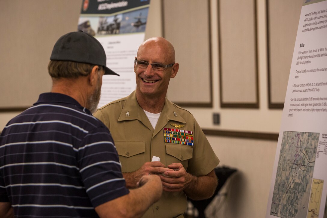 Col. David A. Suggs, the commanding officer of Marine Corps Air Station (MCAS) Yuma, and several base personnel interact with members of the local Yuma community during the Air Installations Compatible Use Zones (AICUZ) Open House at the Pivot Point Conference Center in Yuma, Ariz., July 17, 2019. The Department of Defense established the AICUZ program to assist local governments and communities in identifying and planning for compatible land use and development in the vecinity of military air installations. The primary functions of the AICUZ study is to present noise contours and accident potential zones for an airfield. (U.S. Marine Corps photo by Sgt. Isaac D. Martinez)