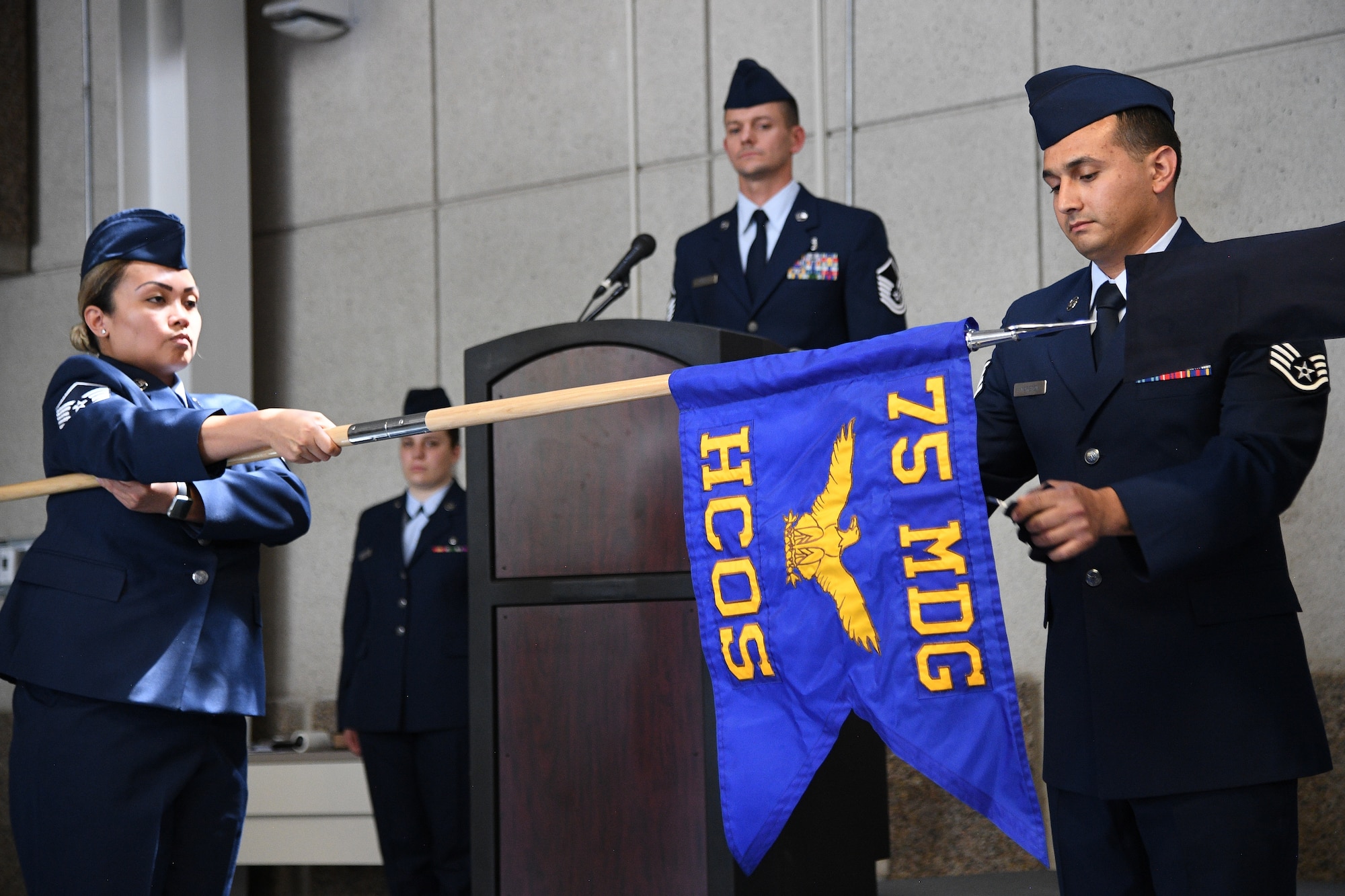 Staff Sgt. Nephi Marsten, a mental health technician, unfurls the 75th Health Care Operations Squadron guidon during an inactivation and redesignation ceremony July 16, 2019, at Hill Air Force Base, Utah. The 75th Medical Operations Squadron was inactivated and redesignated as the 75th Health Care Operations Squadron. The change is part of an Air Force initiative to improve patient care and military readiness. (U.S. Air Force photo by R. Nial Bradshaw)