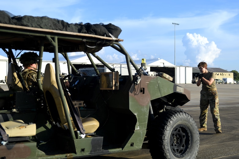A woman marshals a Humvee.
