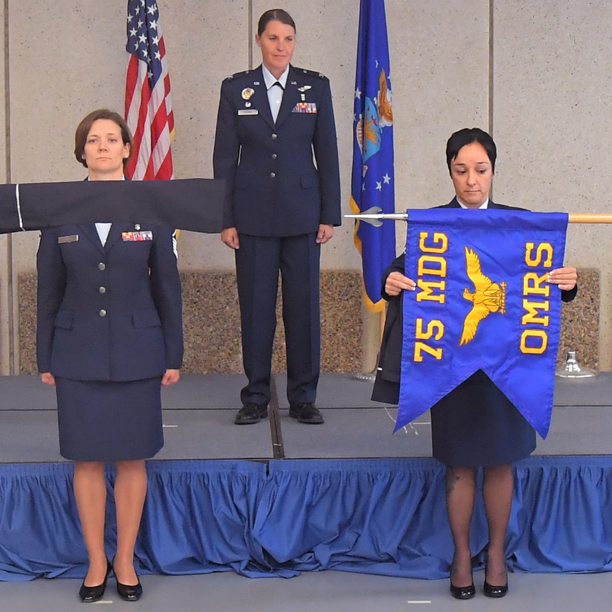 Master Sgt. Veronique Ouchana, public health flight chief, unfurls the unit’s new guidon during a squadron inactivation and redesgination ceremony July 12, 2019, at Hill Air Force Base, Utah. During the ceremony, the 75th Aerospace Medicine Squadron was inactivated and then redesignated as the 75th Operational Medical Readiness Squadron. The change is part of an Air Force initiative to improve patient care and military readiness. (U.S. Air Force photo by U.S. Air Force photo by Todd Cromar)