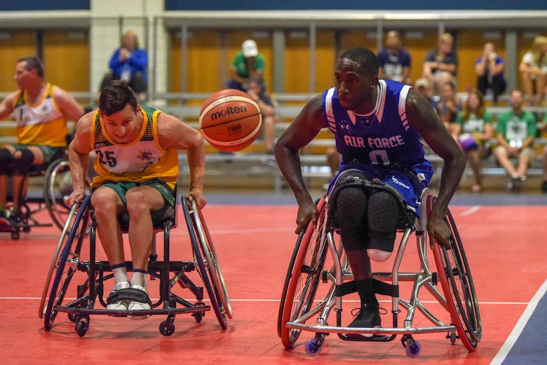 U.S. Air Force Staff Sgt. Kevin Greene, Team Air Force, and Australian Army veteran Private Rye Shawcroft, Team Australia, hustle for a ball during the 2019 DoD Warrior Games wheelchair basketball tournament in the Tampa Convention Center, June 25, 2019. The Warrior Games were established in 2010 as a way to enhance the recovery and rehabilitation of wounded, ill and injured service members and expose them to adaptive sports. Approximately 300 athletes are participating in 13 adaptive sport competitions June 21-30. The athletes represent the United States Army, Marine Corps, Navy, Air Force and Special Operations Command. Athletes from the United Kingdom, Australia, Canada, the Netherlands, and Denmark will also compete. (DoD photo by Staff Sgt. Vito T. Bryant)