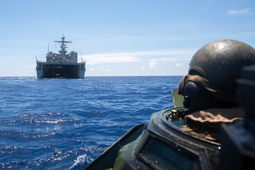 An amphibious assault vehicle approaches a ship.