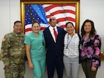 Retired Sgt. Mario Lopez poses for a photo with Brooke Army Medical Center staff members after his painting of the American flag is unveiled in the Medical Mall of the hospital at Joint Base San Antonio-Fort Sam Houston. Lopez, a former BAMC patient who was severely injured in an IED attack in Afghanistan in 2008, learned to use painting therapeutically to help him overcome an array of challenges he has faced over the past decade. The painting was donated to BAMC by former United Nations Ambassador Warren W. Tichenor.