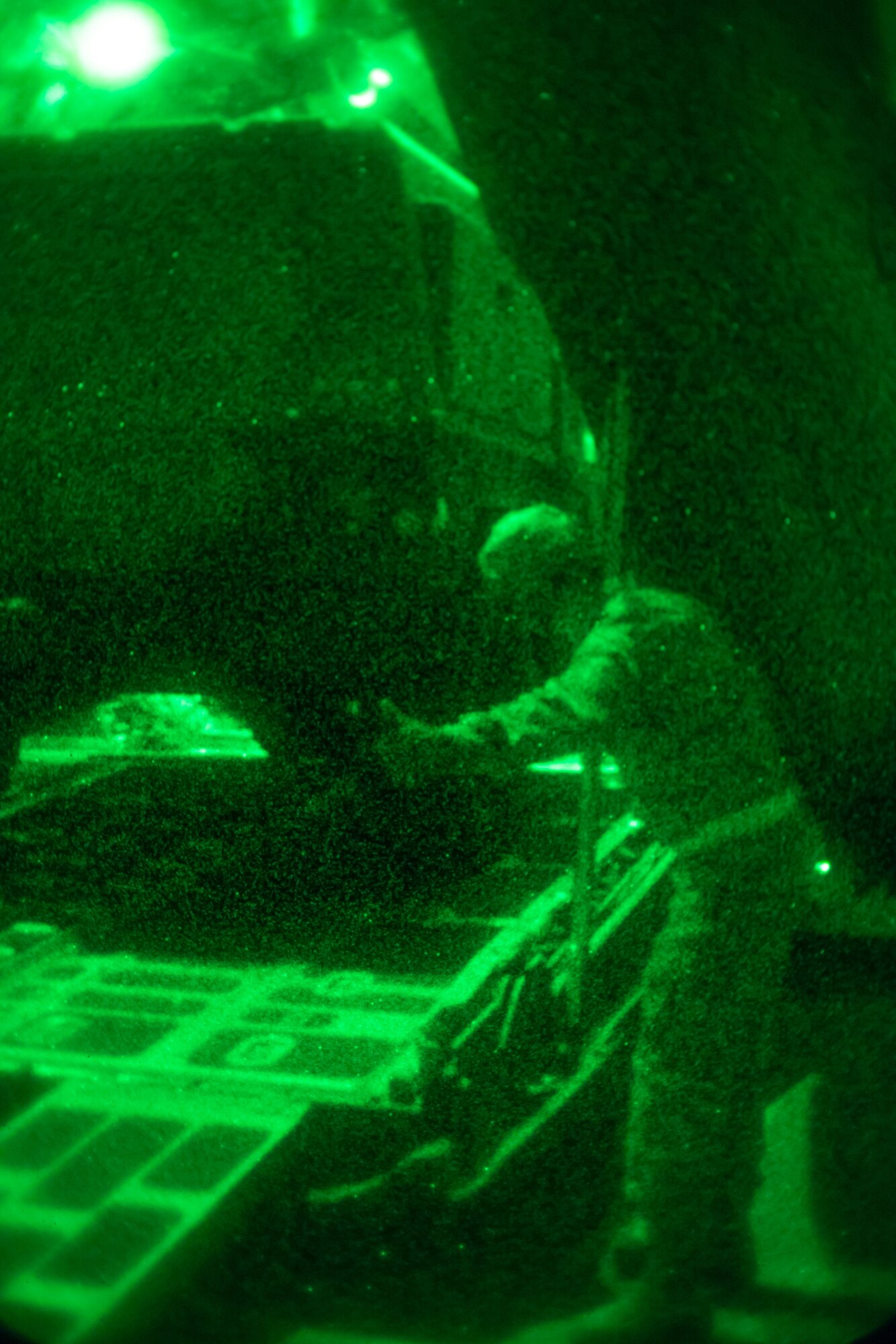 An Airman provides guidance using hand gestures to help load a vehicle to a C-130.