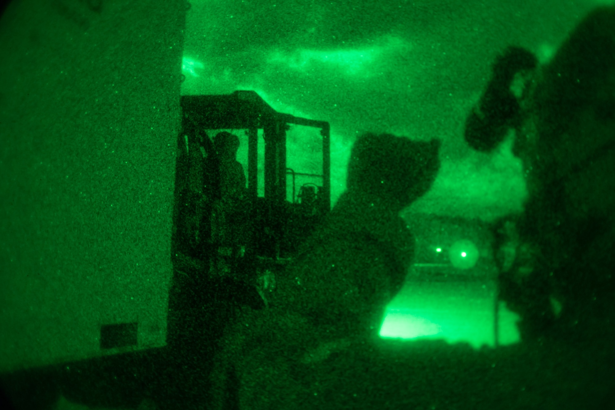 An Airman provides guidance using hand gestures to help load cargo to a C-130.