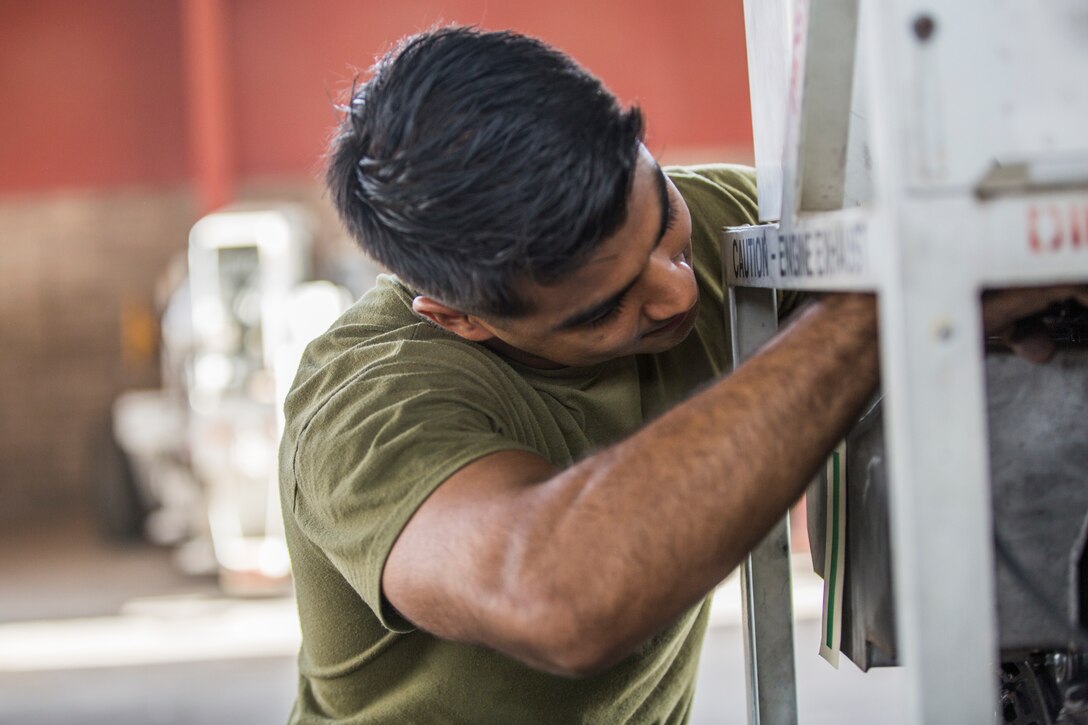 U.S. Marine Corps Lance Cpl. Alejandro Saavedra, a support equipment electrician assigned to Marine Aviation Logistics Squadron (MALS) 13, installs a fuel tank on a demineralization cart at Marine Corps Air Station (MCAS) Yuma, Ariz., July 17, 2019. (U.S. Marine Corps photo by Cpl. Sabrina Candiaflores)