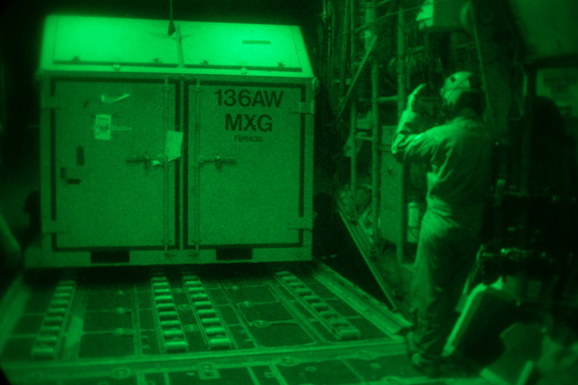 136th Air National Guardsmen guide the loading of cargo into a C-130.