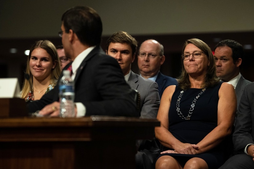 Man at table turns toward family members sitting behind him.