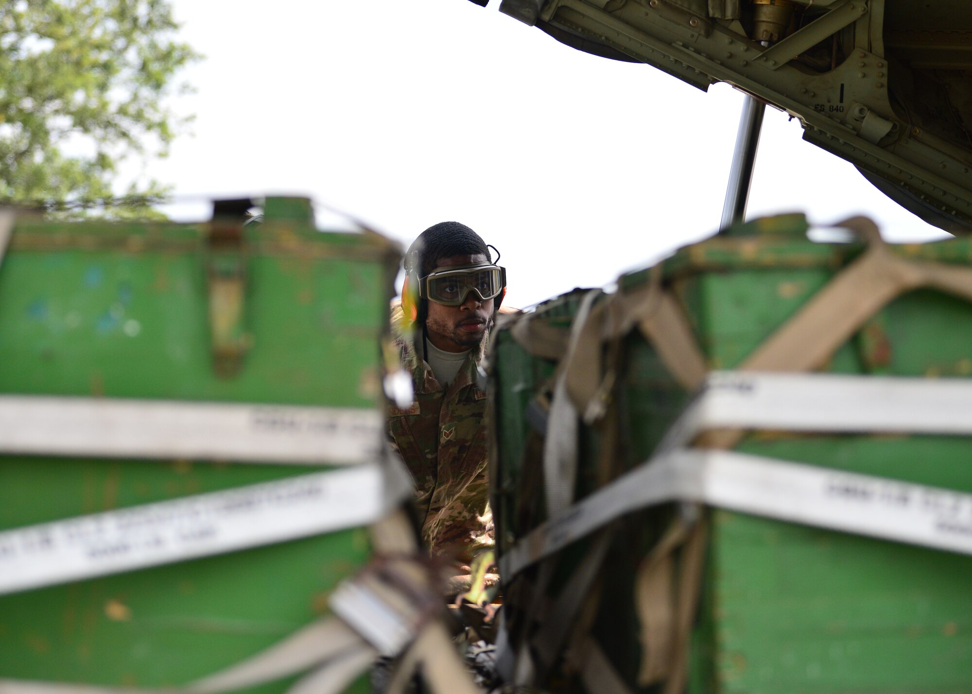 U.S. Air Force Senior Airman Kenneth Saunders, 435th Contingency Response Squadron mobile aerial porter, examines a pallet at Powidz Air Base, Poland, July 13, 2019. As a mobile aerial porter, Saunders assisted in teaching new processes and techniques to his Polish counterparts during Aviation Rotation 19-3. (U.S. Air Force photo by Staff Sgt. Jimmie D. Pike)