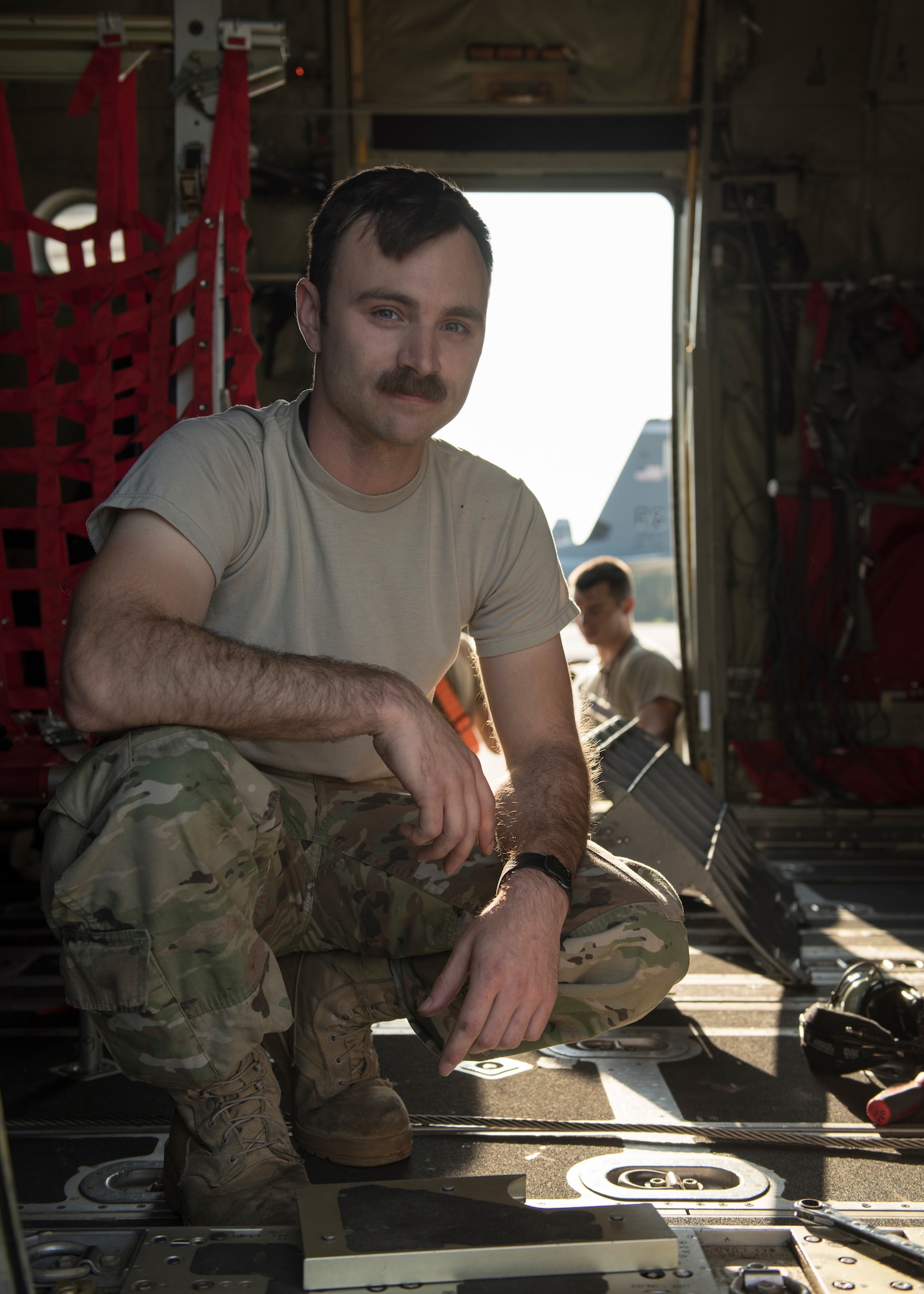 U.S. Air Force Staff Sgt. Joshua Poindexter, 86th Aircraft Maintenance Squadron flying crew chief, kneels on a C-130J Super Hercules aircraft at Powidz Air Base, Poland, July 15, 2019. As a crew chief, Poindexter is responsible for general aircraft maintenance and repairs, which keep the aircraft capable of completing missions. (U.S. Air Force photo by Staff Sgt. Devin Nothstine)