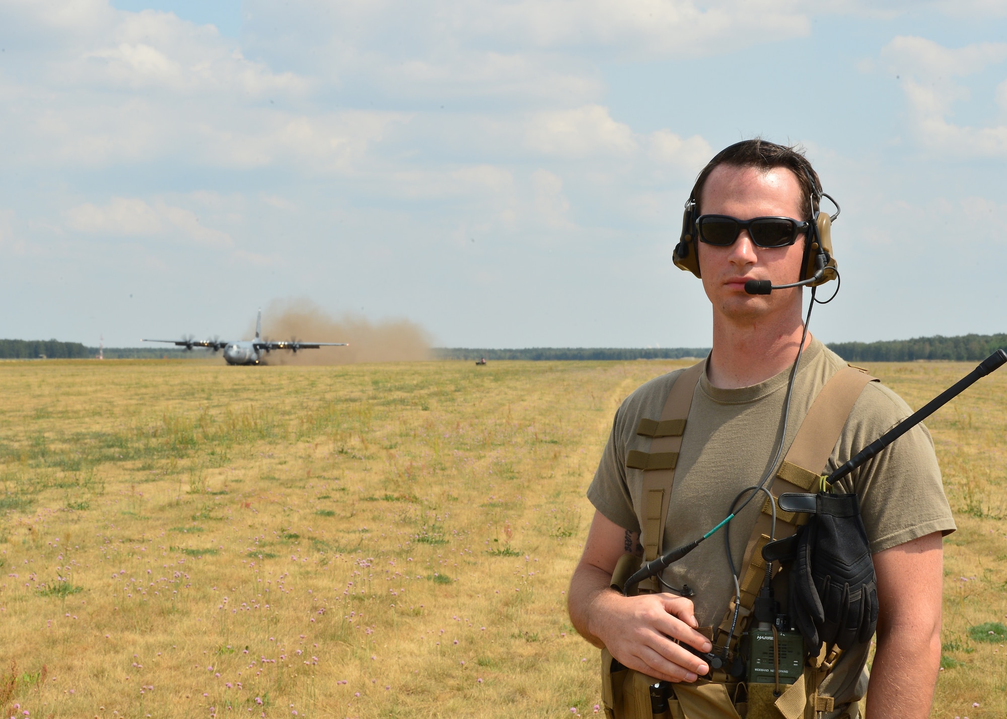 U.S. Air Force Staff Sgt. David Valine, 435th Contingency Response Squadron landing zone safety officer, provides control support for Airmen deployed in support of Aviation Rotation 19-3 at Powidz Air Base, Poland, July 20, 2019. Landing zone safety officers set up landing strips, communicate with incoming aircraft, and ensure the integrity of the landing area for a safe arrival of aircraft. (U.S. Air Force photo by Staff Sgt. Jimmie D. Pike)