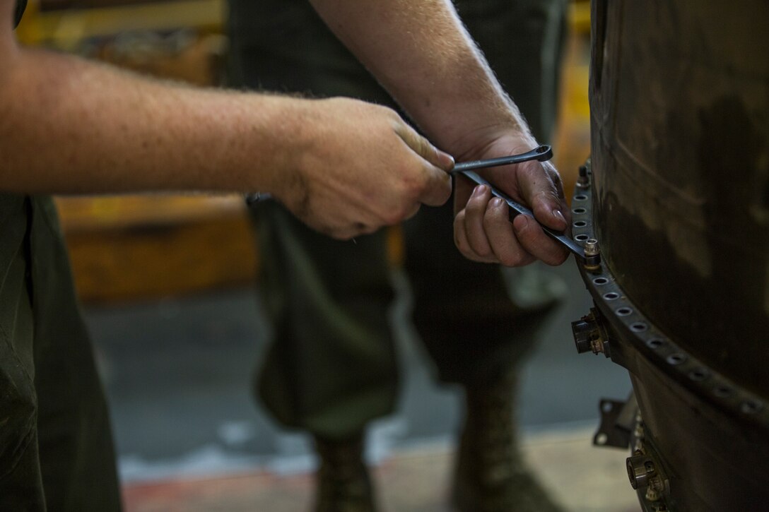 U.S. Marines assigned to Marine Aviation Logistics Squadron (MALS) 13, break down the engine of an AV-8B Harrier at Marine Corps Air Station (MCAS) Yuma, Ariz., July 17, 2019. These Marines are fixed-wing aircraft power plants mechanics. (U.S. Marine Corps photo by Cpl. Sabrina Candiaflores)