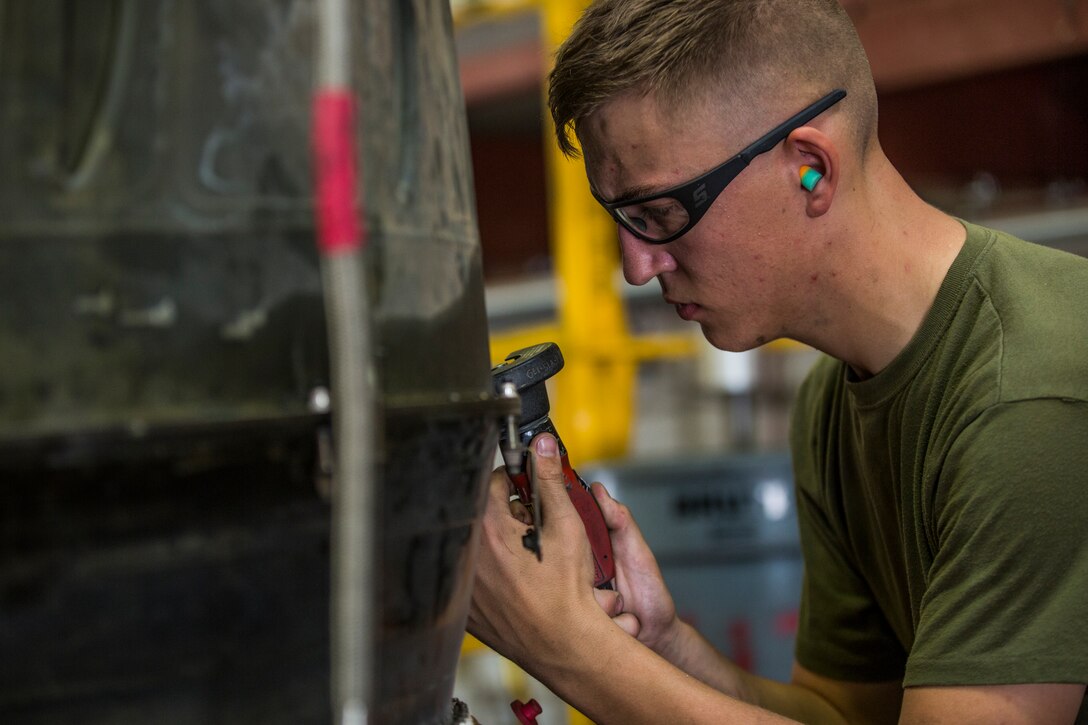 U.S. Marines assigned to Marine Aviation Logistics Squadron (MALS) 13, break down the engine of an AV-8B Harrier at Marine Corps Air Station (MCAS) Yuma, Ariz., July 17, 2019. These Marines are fixed-wing aircraft power plants mechanics. (U.S. Marine Corps photo by Cpl. Sabrina Candiaflores)