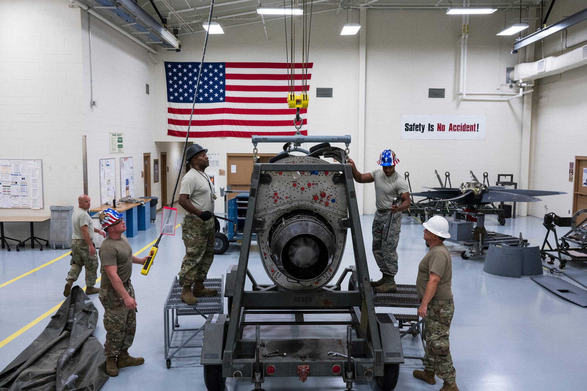 Master Sgt. Donald Maloid, 403rd Aircraft Maintenance Squadron aerospace propulsion supervisor (black helmet) and crew, watches the crane winch lowered on an engine July 14, 2019 at Keesler Air Force Base, Mississippi. The “prop” shop is responsible for the blades as well as the nearly one ton engines they’re attached to. (U.S. Air Force photo by Tech. Sgt. Christopher Carranza)