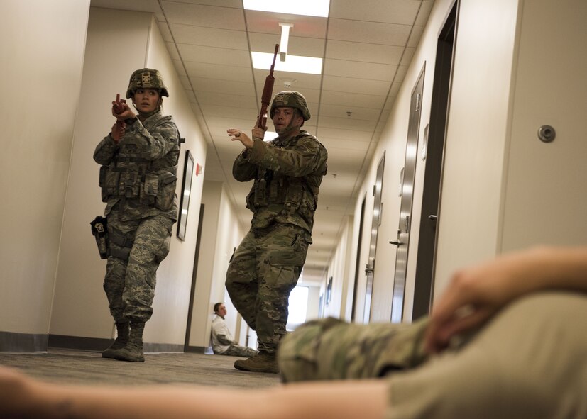 SCHRIEVER AIR FORCE BASE, Colo.--Airman 1st Class Izabel Gutierrez, 50th Security Forces Squadron response force member, left, and Staff Sgt. Nathaniel Propst, 50th SFS response force leader, clear and move down a hallway after neutralizing a suspect in a simulated active shooter scenario during a field training exercise at Schriever Air Force Base, Colorado, July 20, 2019. The 50th SFS conducted the exercise to ensure Defenders remain fit and professional in the base’s defense.  (U.S. Air Force photo by Matthew Coleman-Foster)
