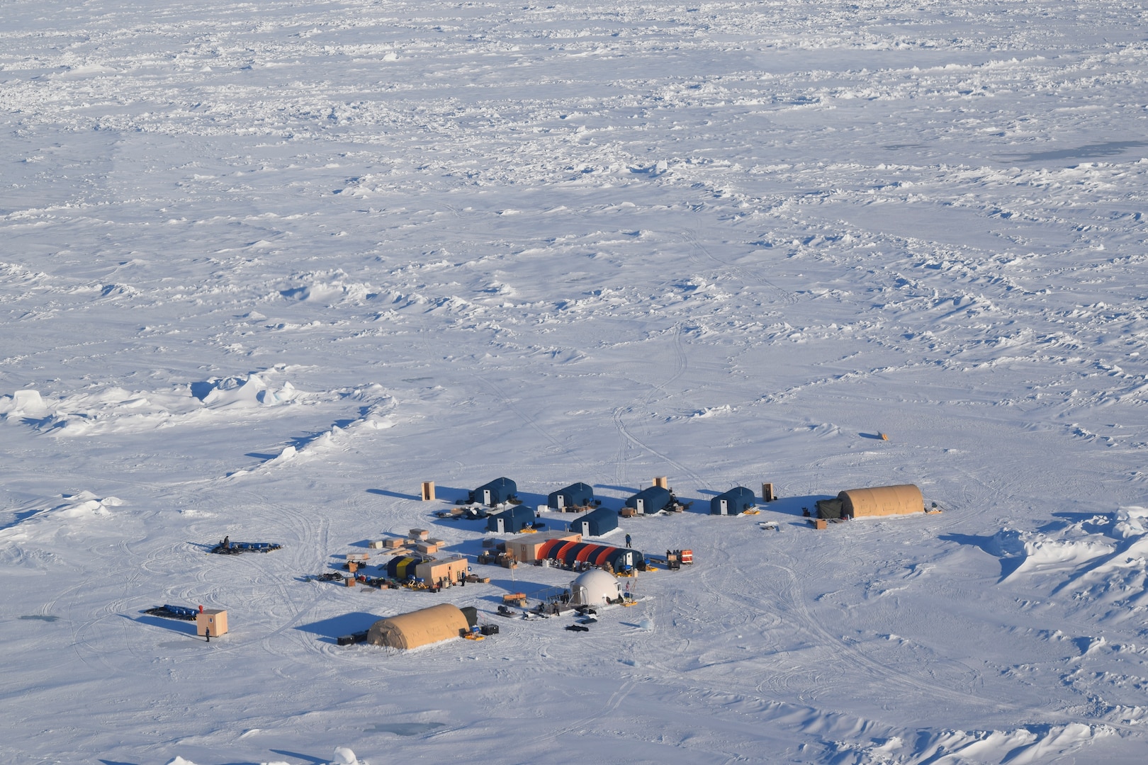 A tiny military camp is surrounded by a vast expanse of snow.
