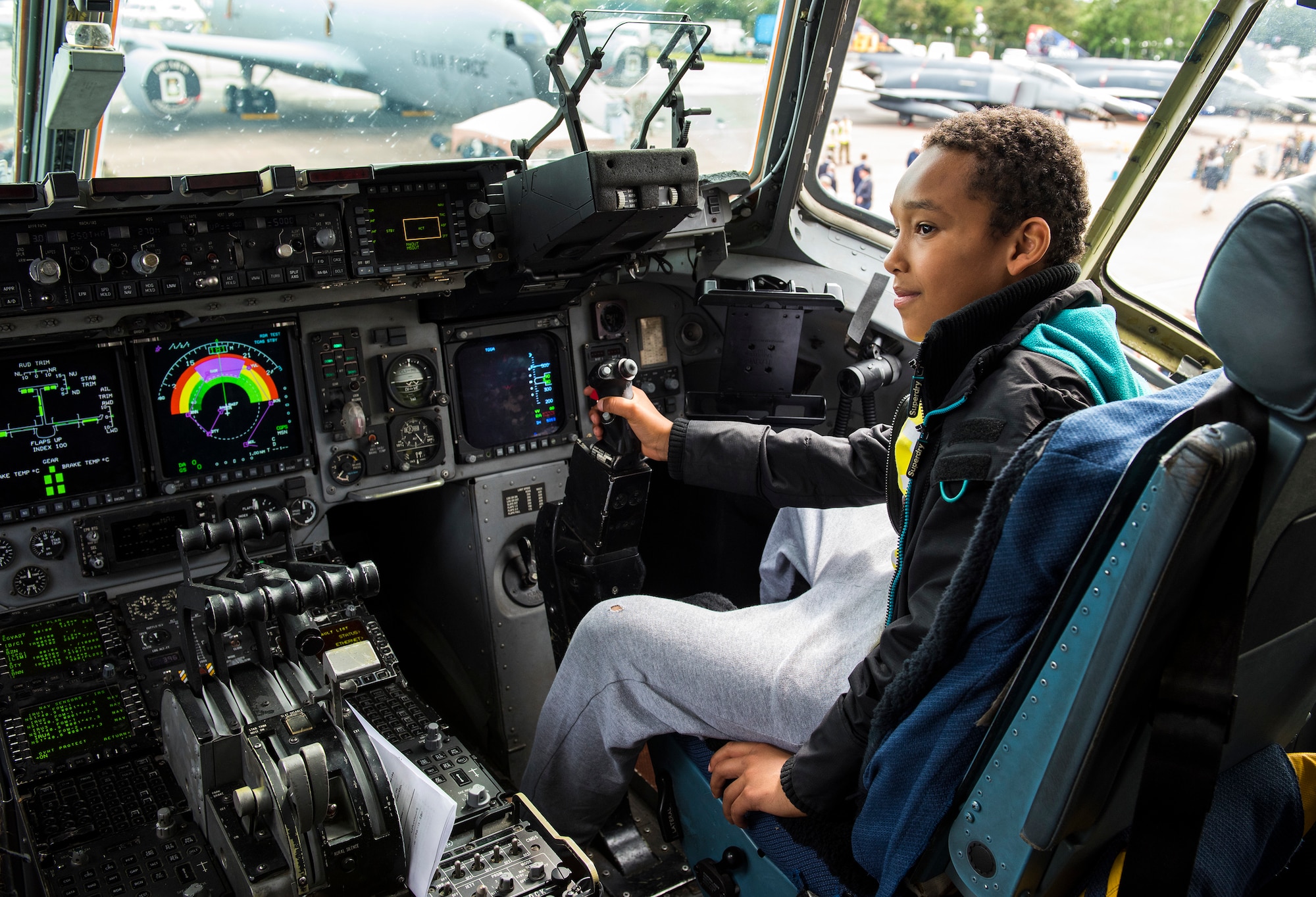 An air show attendee sits inside the cockpit of a U.S. Air Force C-17 Globemaster III static display from Charleston Air Force Base, South Carolina, during the 2019 Royal International Air Tattoo at RAF Fairford, England, July 20, 2019. This year's RIAT commemorated the 70th anniversary of NATO and highlighted the United States' enduring commitment to its European allies. (U.S. Air Force photo by Airman 1st Class Jennifer Zima)