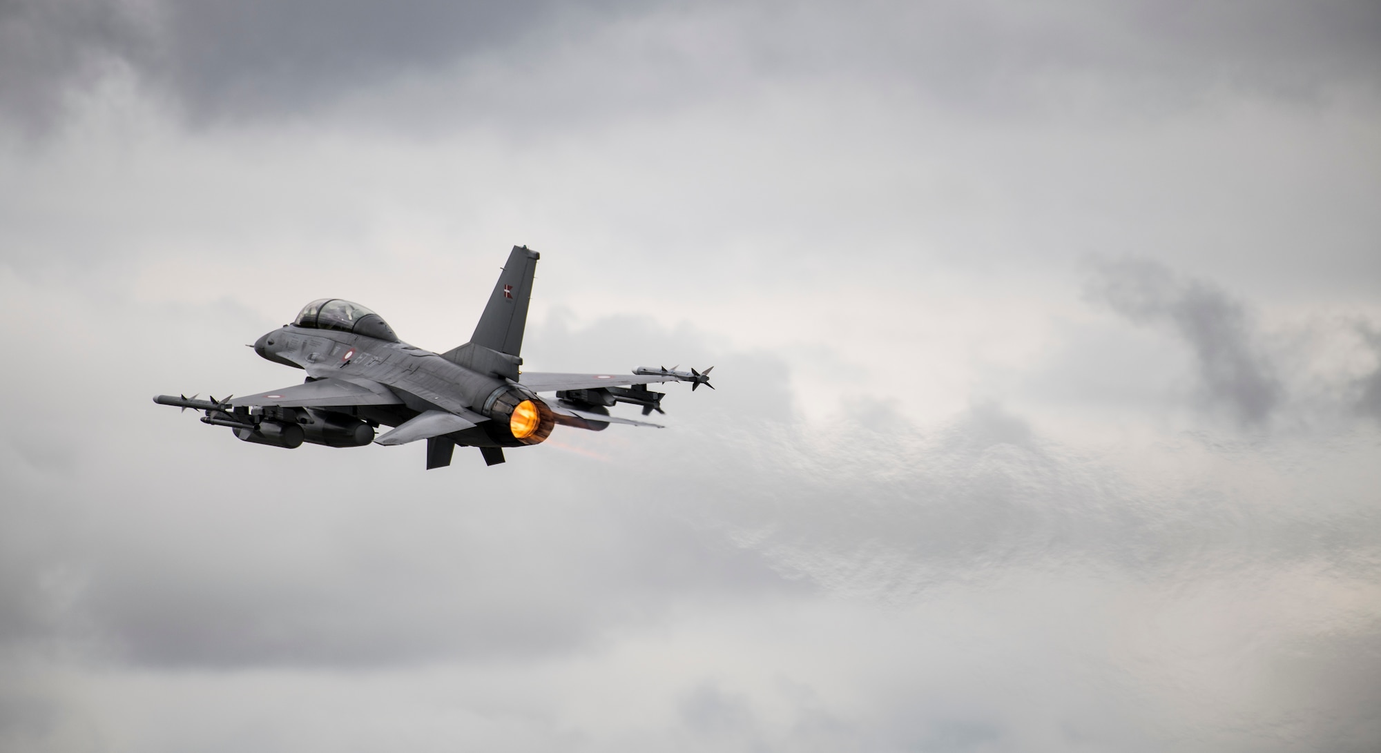 A Danish Air Force General Dynamics F-16AM/BM Fighting Falcon flies past the audience during the NATO 70th Anniversary Flypast at the 2019 Royal International Air Tattoo at RAF Fairford, England, July 20, 2019. This year, RIAT commemorated the 70th anniversary of NATO and highlighted the United States' enduring commitment to its European allies. (U.S. Air Force photo by Airman 1st Class Jennifer Zima)