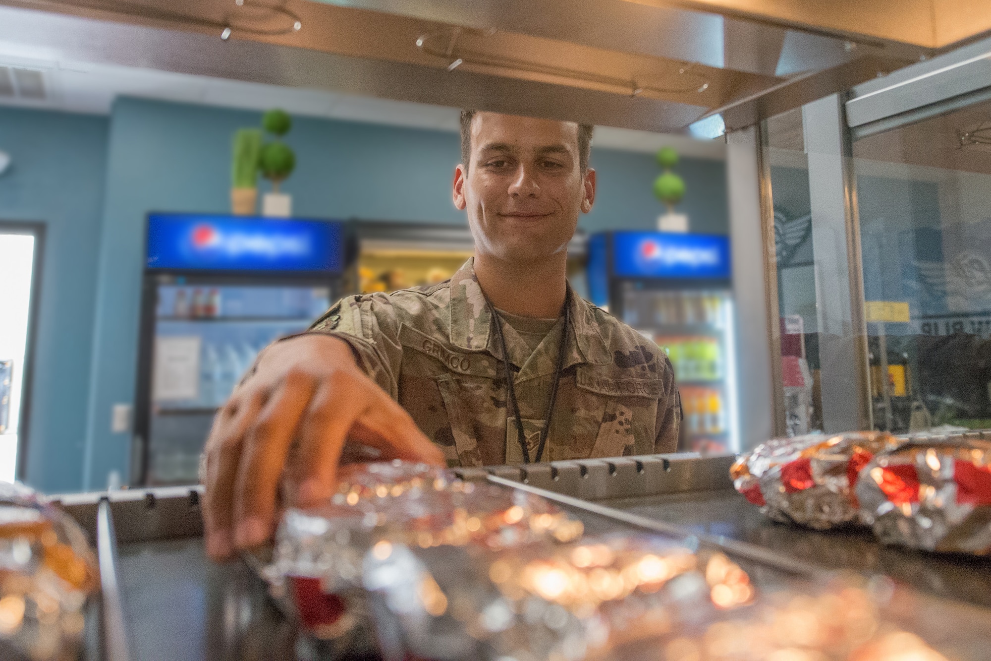 Staff Sgt. Bryon Grimco, 736th Maintenance Squadron C-17 aerospace maintenance journeyman, grabs a sandwich to go from The Lift kiosk June 22, 2019, at Dover Air Force Base, Del. Designed for convenience, the kiosk offers the same “grab-and-go” items available at the DFAC, as well as entrée items at a location close to the flight line. (U.S. Air Force photo illustration by Mauricio Campino)