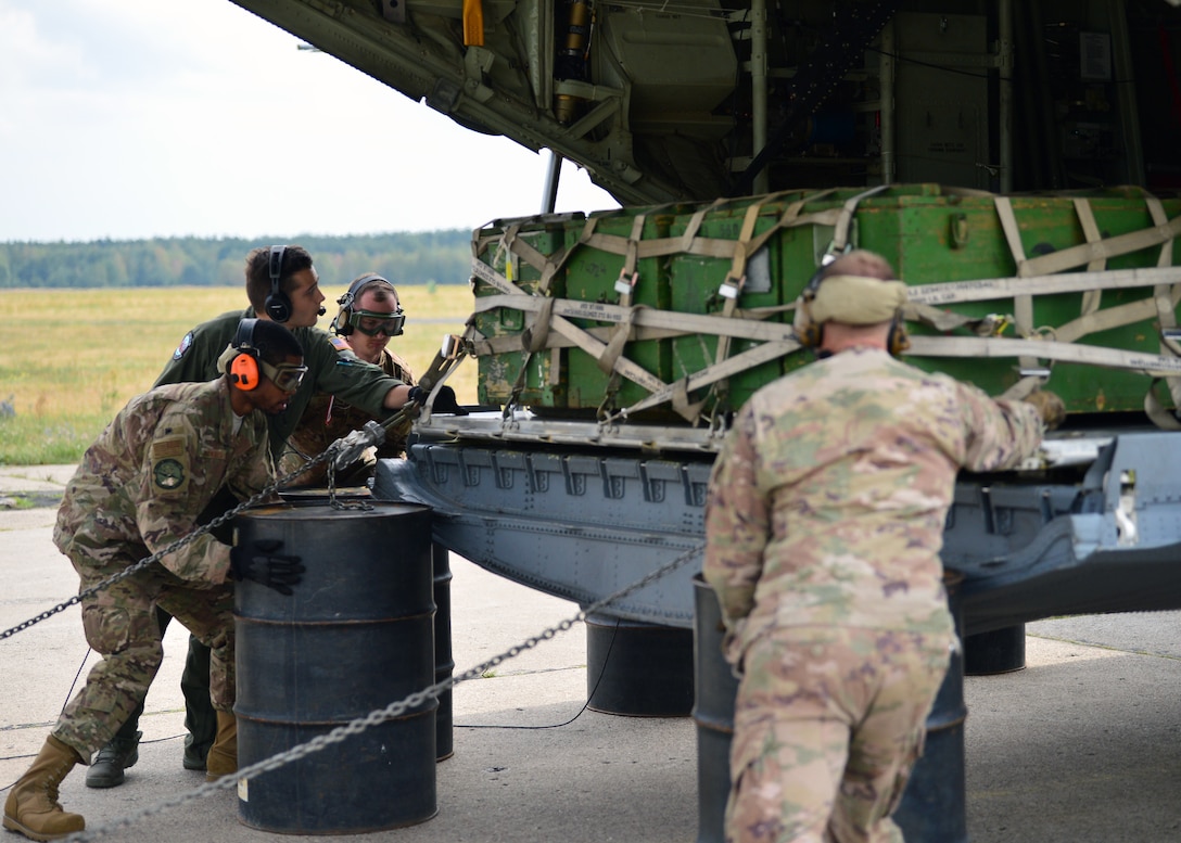 U.S. Air Force Airmen deployed to Powidz Air Base, Poland, perform a combat offload bravo July 20, 2019. Method bravo requires the use of barrels to set the pallets on and is used when aircraft loaders are unavailable at a destination. (U.S. Air Force photo by Staff Sgt. Jimmie D. Pike)